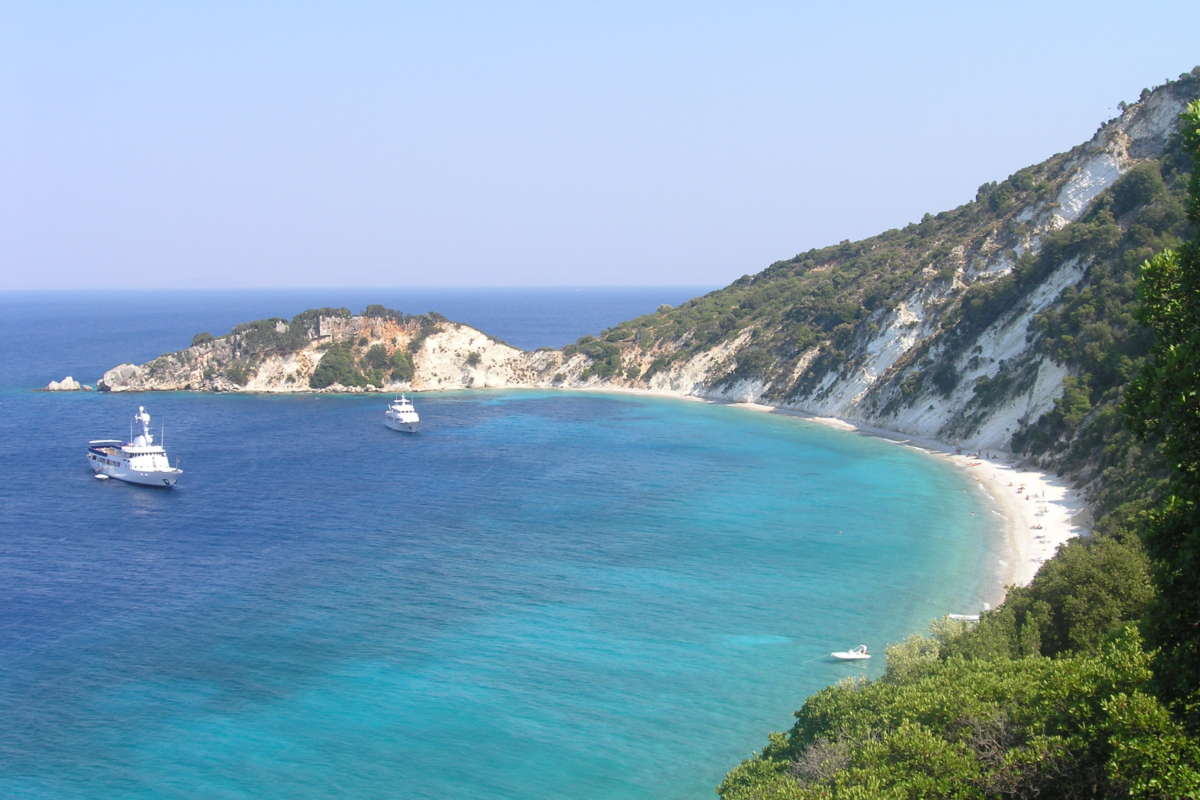 Ithaki Travel Guide: Best Tours, Boat Trips, And Island Experiences When people ask me which Greek island still feels truly authentic, Ithaca (or Ithaki as we say in Greek) is always near the top of my list. It's small, green, and quiet, but the coastline is wild and dramatic, perfect for boat tours, sea caves, and hidden coves that you simply can't reach by car. In this Ithaki travel guide I'll walk you through the best boat tours and trips, how to visit Ithaca island, how to get there (especially from Kefalonia), and how to plan a realistic itinerary with beaches, villages, and hikes. I'll also share the small, practical things I've learned over many summers island-hopping all over Greece. Whether you're planning a relaxed family trip to Ithaca Greece, a romantic escape with sunset cruises, or a more active holiday with kayaking, snorkeling, and hiking, this guide will help you choose the right Ithaca tours, book ferries, and avoid the usual first‑timer mistakes. Let's start with why Ithaca is so special among the Ionian Islands. Why Visit Ithaca (Ithaki): Myth, Nature, And Ionian Island Charm Ithaca is famous as the homeland of Odysseus, but it's much more than a mythological name on a map. When I first approached Ithaki by boat, what struck me most was how unspoiled it felt compared with more famous neighbors like Kefalonia and Corfu. The coastline is steep and deeply indented, which means countless small coves, turquoise water, and white-pebble beaches that look like they belong in a travel brochure. Many of the best beaches in Ithaca Greece are only accessible by boat or a serious hike, so boat tours aren't just "nice to have" here – they're the key to really seeing the island. Inland, Ithaca is a patchwork of cypress trees, olive groves, and tiny traditional villages where life still follows a slower rhythm. You'll find old men drinking Greek coffee in village kafenia, fishing boats unloading in the harbor of Vathy, and kids jumping from the quay at sunset. Compared with other Ionian Islands, Ithaca tourism is low-key: fewer big resorts, more small family-run hotels and rooms, and a strong local character. If you're looking for loud nightlife, this isn't your island. If you're dreaming of clear water, quiet bays, boat trips, good food, and a sense that you're in "real" Greece, Ithaca delivers. And of course, there's the mythology. From the Cave of the Nymphs to sites associated (rightly or wrongly) with Odysseus's palace, the island is full of places where legend and landscape overlap. Even if you're not a history nerd, it adds a special atmosphere when you're sailing into a bay knowing poets have written about it for 3,000 years. How To Get To Ithaca Island And Around The Island Reaching Ithaca Greece is a little more involved than flying into a big resort island, but that's exactly why it has stayed so peaceful. There's no airport on Ithaca, so you'll come by sea – usually via Kefalonia or the Greek mainland. Ferries To Ithaca Greece: Routes, Tickets, And Practical Tips The most useful routes for most travelers are: Ithaca ferry from Kefalonia This is the classic combination. You can: Take a ferry from Sami (Kefalonia) to Pisaetos (Ithaca) – usually the simplest and most frequent route in summer. In some seasons, there are also connections via Poros (Kefalonia). Patras to Ithaca ferry (via Kefalonia) On the mainland, Patras is a major port in western Greece. Ferries typically run Patras → Sami (Kefalonia) and then you connect onward to Ithaca. It's not usually a direct Patras–Ithaca line, so think of it as a two-step journey: mainland to Kefalonia, then Kefalonia to Ithaca. Other mainland ports (Kyllini, Astakos) From Kyllini you sail to Kefalonia, then continue to Ithaca. From Astakos on the mainland you may find seasonal connections to Ithaca or via Kefalonia. These options change more often, so I always double‑check closer to travel dates. How to book ferry to Ithaca For Ithaca travel in July–August, I always recommend booking tickets in advance, especially if you have a car. Use major Greek ferry comparison sites or book directly on the ferry company's website. For shoulder season (May–June, September), last-minute tickets at the port are usually fine for foot passengers. A couple of practical tips: Check both Ithaki and Ithaca spellings on booking sites. Watch for two ports on the island: Pisaetos (main ferry port) and Vathy (some services, usually smaller boats or excursions). Ferry schedules are seasonal, and routes or times may change year to year. Ithaca Transportation Guide: Getting Around By Car, Bus, Taxi, And Boat Once you arrive, Ithaca is quite compact but mountainous, with winding roads and a lot of views. To enjoy the island fully, especially traditional villages and trailheads for hiking in Ithaca, I strongly prefer having my own wheels. Car or scooter rental Best option for flexibility, especially if you're staying outside Vathy or want to explore the north around Stavros and Frikes. Reserve in advance in high season – small islands run out of cars quickly. Bus There is a basic local KTEL bus connecting Vathy with some villages, but it's limited and tailored more to local needs than tourists. Don't plan your whole Ithaca itinerary around bus times – use it as backup, not your main tool. Taxi Available in Vathy and main villages: handy for short transfers (for example, port to hotel) or if you want to hike in one direction and take a taxi back. Always ask for an approximate price before you get in. Boat For Ithaki, the real transportation magic happens on the water. You can: Join organized boat tours around Ithaca. Rent a small self-drive boat (no license for low-horsepower boats, but always follow safety rules). Combine taxis or buses inland with boat trips from Vathy, Kioni, or Frikes. If you don't feel like driving at all, you can still see a lot by basing yourself in Vathy and relying on boat tours and a few taxi rides, but you'll enjoy the island more with at least some independent transport. Top Ithaki Boat Tours And Day Trips Boat tours are the number one experience I recommend for Ithaca travel. The island's best beaches, caves, and coastal scenery reveal themselves only when you're out on the water. Classic Boat Tours Around Ithaca Most classic boat tours around Ithaca start from Vathy, Kioni, or Frikes and usually run as full-day or long half‑day trips. Typical highlights include: Gidaki Beach – often reached only by boat: a long, white-pebble beach with unbelievable turquoise water. Afales Bay – dramatic cliffs, scattered small coves, and some of the best swimming in Ithaca Greece. Cave of the Nymphs (Nymfon) – associated with Odysseus: some tours point it out from the sea or stop nearby. Small fishing ports – like Kioni or Frikes for a lunch stop, coffee, or a quick stroll. On these tours, you'll usually have several swimming stops, snorkeling opportunities, and a relaxed lunch break at a seaside taverna. For first-time visitors who want a single, all‑round introduction to Ithaca attractions by sea, this is the tour I'd start with. Island-Hopping Trips In The Ionian Islands From Ithaca If, like me, you love combining islands, Ithaca is a great base for Ionian island-hopping by boat. From Ithaca you can find boat trips or transfers to: Kefalonia – often to Sami, Fiskardo, or small northern coves. Atokos – an uninhabited islet with crazy-blue water, ideal for swimming and snorkeling. Arkoudi, Meganisi or Lefkada (on some itineraries) – more common as private or semi-private trips. These tours are perfect if you're staying 5–7 days on Ithaca and want to see more of the Ionian Islands without re‑packing your luggage. Think of them as day-hopping rather than full-on relocation. Private, Luxury, And Small-Group Boat Tours For honeymooners, families, or groups of friends who prefer flexibility, private or small‑group boat tours are worth the extra money. What I personally like about private Ithaca boat tours: Custom itinerary – want more time on a hidden beach and less at crowded stops? Easy. Timing control – you can leave earlier or later to avoid the busiest hours, especially in July–August. Special interests – photography, snorkeling, fishing, or visiting specific bays you've researched. Options include: RIB or speedboat tours – fast and fun, great for covering more coastline. Traditional wooden kaiki – slower, more atmospheric, and usually more spacious. Yacht or catamaran day charters – the most comfortable (and most expensive) way to spend a day at sea. If you're visiting in peak season, I'd reserve at least one boat trip before you arrive, especially if your dates are fixed or you're traveling with kids. Adventure On The Water: Kayaking, Sailing, And Snorkeling In Ithaca If you're like me and can't sit still on a beach for too long, Ithaca offers plenty of active ways to enjoy the sea beyond standard boat tours. Kayaking In Ithaca: Caves, Cliffs, And Calm Bays Kayaking in Ithaca is one of the best ways to feel close to the coastline. Guided sea-kayak trips usually: Start from Vathy or Kioni, depending on the route. Follow calm stretches of coast with high cliffs and small caves. Include swim and snorkel stops in quiet bays. Because Ithaca sits in the protected Ionian Sea, conditions are often ideal for beginners, especially in the morning when winds are lighter. Multi-hour tours are common, and some outfitters offer sunset paddles, which I always recommend if you're visiting in the heat of July or August. If you rent a kayak independently, stay close to shore, watch boat traffic, and avoid crossing large open bays unless you really know what you're doing. Sailing Trips, Fishing Excursions, And Sunset Cruises If your dream is to raise the sails and glide between islands, you'll find: Day-sailing trips along Ithaca's coast with swim stops and lunch on board. Multi-day sailing holidays that include Ithaca, Kefalonia, Lefkada, and smaller islands like Meganisi. Even if you're not interested in handling the sails, you can join as a passenger and let the skipper worry about the wind while you focus on the views. For something more local and down-to-earth, look for: Fishing excursions with Ithacan skippers – early-morning trips where you can help pull in nets or lines and sometimes eat your catch later in a taverna. Short sunset cruises – usually 1.5–3 hours, perfect if you're traveling with kids or don't want a full day at sea. Where there's clear water there's always good snorkeling, and Ithaca is no exception. Most boat tours will happily lend basic equipment, but if you're serious about snorkeling, I always suggest bringing your own mask – nothing ruins a perfect cove like a leaking rental mask. Best Beaches In Ithaca Greece To Visit By Boat When I plan Ithaca travel itineraries for friends, I always start from the beaches and work backwards. The coastline is the island's main "wow" factor, and seeing it from the sea changes everything. Iconic Ithaca Beaches You Should Not Miss Some of the best beaches in Ithaca Greece are classics for a reason: Gidaki Beach – Long, curved, white pebbles and crystal water. Accessible by boat and also by a demanding path: in summer, small shuttle boats run from Vathy. Afales Bay (Afales Beach and nearby coves) – In the north, beneath high cliffs. Many boat tours anchor here for swimming. Skinos Bay – Protected and green, great for calm anchorage and relaxed swims. Dexa Beach – Near Vathy, linked with Odysseus legends: easy to access by road but also a nice short boat-stop. Visit at least one of these by boat so you see the full color of the water and the surrounding cliffs. Hidden Beaches In Ithaca Island Accessible Only By Boat Or Hike Ithaca's magic really reveals itself in the smaller, unnamed coves. Around Afales, the east coast south of Vathy, and the areas between Kioni and Frikes, you'll find: Tiny pebble coves with no facilities at all – just rocks, trees and sea. Sea caves where the water turns deep electric blue. Short strips of pebble beach under cliffs that you'll likely share with only a few other boats. These are the hidden beaches in Ithaca island that organized tours often include as "secret spots". If you rent a self-drive boat, always follow local advice about safe anchoring and distances from the shore. Family-Friendly Beaches And Stops On Boat Tours For family travel to Ithaca Greece, you want beaches with: Relatively calm water and shelter from wind. Easy shore access (not too many slippery rocks). Options for shade and snacks. Good candidates include: Filiatro Beach – Near Vathy, partly organized, usually a stop or at least a pass-by on some boat trips. Gidaki – Fine with kids who are comfortable in deeper water: bring sun protection, as natural shade is limited. Kioni Bay – Not a classic big beach, but a lovely stop for swimming off the boat and then ice cream or lunch in the village. When booking Ithaca boat tours, tell the operator you're with children. Skippers are usually happy to adjust the route to include more relaxed, kid-friendly stops and shorter hops between bays. Things To Do In Ithaca Beyond The Sea I love the sea, but even I need a day or two on land. Luckily, Ithaca offers a good mix of villages, gentle hikes, and cultural sites that fit nicely around your boat days. Vathy Ithaca: Harbor Life, Cafés, And Evening Strolls Vathy is the main town and heart of Ithaca tourism. It sits in a deep, naturally protected bay that looks especially beautiful when you sail in. In Vathy you can: Wander the harborfront promenade, watching fishing boats and yachts. Sit at a café for a Greek coffee or iced freddo and just people‑watch. Visit the Archaeological Museum of Ithaca and Folk & Maritime Museum to get a feel for Ithaca history and culture. Shop for local products like olive oil, thyme honey, and handmade soaps. In the evening, I like to take a slow walk around the harbor, then stop at a taverna for fresh fish or a big plate of meze. Traditional Villages In Ithaca And Cultural Sites To Explore Outside Vathy, the island is dotted with traditional villages: Stavros – A key village in the north, with a small square and a museum with finds linked to Odysseus. Kioni – Picture‑perfect harbor with stone houses, flowers, and seaside tavernas. Frikes – Small fishing village with a few excellent places to eat by the water. Among cultural sites in Ithaca Greece, don't miss: Archaeological sites around Stavros and Pilikata, connected with possible locations of Odysseus's palace. Churches and chapels with nice views, like those around Perachori. Remains from the Venetian and later periods, visible in architecture and village layouts. Hiking In Ithaca: Scenic Trails, Viewpoints, And Odysseus Legends For such a small island, hiking in Ithaca is surprisingly rewarding. Trails are generally short to medium length and combine: Sea views over the Ionian Islands and mainland. Old stone paths, terraces, and olive groves. Sites named after Homeric locations, like Aetos, Arethousa Spring, or paths near Anogi. Bring proper shoes (not just flip‑flops from the beach), plenty of water, and start early in summer to avoid the heat. Many routes are well cleared nowadays, but a simple offline map helps a lot. Best Places To Visit In Ithaca: A Quick Island Bucket List If you like simple lists, here's a quick best places to visit in Ithaca starter set: Vathy – harbor, museums, evening atmosphere. Gidaki Beach – classic "wow" factor. Afales Bay – cliffs + turquoise water. Kioni and Frikes – traditional seaside villages. Stavros – for Odysseus-themed history. Perachori & viewpoints above Vathy – amazing panoramas. A boat-access only cove or two – ask your skipper for their favorite. Plan at least one full boat day, one land-based day with villages and a short hike, and then adjust based on how much time you have. Suggested Ithaca Travel Itineraries With Tours And Boat Trips To make all this practical, here's how I'd structure your time on the island, with a focus on boat tours and sea activities. 3-Day Ithaca Itinerary: Highlights And A Signature Boat Tour Day 1 – Arrival and Vathy Arrive via ferry to Pisaetos and transfer to your hotel in Vathy. Evening stroll around the harbor, dinner at a seaside taverna. If you arrive early, quick swim at nearby Filiatro or Dexa. Day 2 – Classic Ithaca boat tour Full-day boat tour around Ithaca, ideally from Vathy. Stops at Gidaki, Afales Bay, and at least one or two hidden coves. Lunch in Kioni or Frikes, with time to walk the village. Return to Vathy in the late afternoon: sunset drink on the waterfront. Day 3 – Villages and viewpoints Rent a car or taxi up to Stavros for a few hours. Continue to Kioni for a relaxed lunch and swim. Optional short hike to a nearby viewpoint. Late afternoon ferry departure or extra night in Vathy. 5–7 Day Ithaca Itinerary: Beaches, Villages, Hiking, And Island-Hopping With a week on Ithaki, you can slow down and mix sea days with land days. Day 1 – Vathy base Arrive, settle into your hotel in Vathy. Evening walk, simple dinner, early night. Day 2 – South & central coast by boat Half or full-day boat trip focusing on Gidaki, Skinos, Filiatro and nearby coves. Snorkeling and relaxed swimming. Back to Vathy for dinner. Day 3 – North villages and Afales Rent a car and drive to Stavros, Frikes, and Kioni. Afternoon swim around Afales (by road or short local boat). Sunset in Kioni. Day 4 – Hiking and viewpoints Morning hike near Perachori or one of the Odysseus-themed trails. Afternoon rest and café time in Vathy. Optional short sunset cruise. Day 5 – Island-hopping day trip Join a boat tour that includes Atokos or a couple of nearby Ionian Islands like Kefalonia's north coast. Lots of swimming and snorkeling in wilder settings. Day 6 – Free day / backup for weather Keep one flexible day in case a boat trip needs to shift due to wind. Use it for another beach day, extra hike, or simply wandering Vathy and buying souvenirs. Day 7 – Last swims and departure Quick morning swim near Vathy. Check out, ferry back to Kefalonia or the mainland. These itineraries work well for 2025–2026 and beyond: the main thing that changes year to year is the exact ferry schedule and which specific boat operators are running. Ithaca Travel Tips: When To Go, What To Know, And How To Book A few smart decisions before you arrive can make your Ithaca travel much smoother. Best Time To Visit Ithaca For Boat Tours And Outdoor Activities May–June – My personal favorite: warm enough for swimming, lush green landscapes, quieter ferries to Ithaca Greece, and more availability for hotels and tours. July–August – Hottest and busiest. Sea conditions are excellent most days, but you must book ferry to Ithaca, accommodation, and popular boat tours well in advance. September–early October – Still warm sea, more relaxed vibe, great for hiking and boat trips without intense heat. Winter and early spring see very limited tourism, and many services close, so they're not ideal for typical Ithaca vacations. What To Know Before Visiting Ithaca: Money, Weather, And Safety A few essentials I always tell friends: Money – Greece uses the euro. Card acceptance is good in most tavernas, hotels, and bigger shops, but I always carry some cash for small cafés, bakeries, and boat-related tips. Weather – Expect strong sun. Even on a breezy boat day, you will burn without sunscreen, hat, and light cover‑up. Safety on the water – Listen to your skipper, respect swim time limits, and don't jump from rocks you haven't checked for depth. For self-drive boats, follow all instructions carefully. Roads – Mountain roads are winding but generally fine: just drive slowly and watch for goats. Family Travel To Ithaca Greece: Practical Advice And Kid-Friendly Tours Ithaca is excellent for families who prefer nature and the sea over amusement parks and shopping malls. My tips for family travel Ithaca Greece: Choose Vathy, Kioni, or Frikes as a base – all have easy access to food, small shops, and relatively calm waterfronts. For boat tours with kids, pick shorter routes (4–6 hours instead of 8–9) and make sure there's shade on board. Pack reef shoes for pebble beaches and occasional rocky entries. Always bring snacks and extra water for kids, even if the tour includes lunch. Most local skippers have families of their own: they're usually very understanding with children and know which stops are best for them. Where To Stay, Eat, And Plan Your Ithaca Vacation You don't need a huge resort to enjoy Ithaca. In fact, most "hotels in Ithaca" are small family places, apartments, and guesthouses – which is exactly what keeps the island charming. Hotels In Ithaca And Best Areas To Stay Where you stay depends on your style: Vathy – Best for first-time visitors and those without a car. Close to many Ithaca attractions, boat tour departures, and bus/taxi options. Kioni – Romantic, quieter, with beautiful harbor views: ideal for couples and those who want to wake up close to the water. Frikes – Small, relaxed base in the north, good for exploring Afales and nearby villages. Countryside rooms and villas – Perfect if you want complete peace and don't mind driving. Book early for July and August, especially if you're after sea-view rooms or family-sized apartments. Ithaca Local Cuisine: Dishes To Try After A Day On The Water Nothing tastes better than Greek food after a long swim. On Ithaca, look for: Fresh fish and seafood – grilled fish, fried gavros (anchovies), octopus in vinegar. Local stews – like stifado (slow-cooked meat with onions) and other home-style dishes. Pies – cheese pies or greens pies, often homemade. Simple but perfect Greek salads, fava (yellow split pea dip), tzatziki, and seasonal vegetables. Ask for local wine or tsipouro, but if you're sailing the next day, don't overdo it. Ithaca Vacation Packages And How To Combine Ferries, Tours, And Stays If you prefer everything connected, you can build your own Ithaca vacation package by combining: Ferries to Ithaca Greece – decide first if you'll route via Kefalonia, Patras, or another mainland port like Kyllini. Accommodation – book at least your first and last nights in advance, ideally in Vathy if it's your first time. Boat tours – reserve at least one classic Ithaca boat tour and, if you're staying longer, one island-hopping or private trip. Leave a little flexibility in your schedule for weather changes – especially if your dream experiences are kayaking in Ithaca or a specific sailing day. When everything is lined up – ferries, room, and at least one or two sea days – the rest of your time can flow naturally with how you feel and what the weather looks like. Conclusion Ithaca may be famous from Homer, but what makes Ithaki unforgettable today is much simpler: clear water, quiet bays, honest food, and an easy rhythm of life. With the right combination of boat tours, a few hikes, and evenings in Vathy or Kioni, you can experience an Ionian island that still feels like a secret. Plan your ferries carefully, book at least one full-day boat trip in advance, and give yourself time both on the sea and in the villages. Do that, and Ithaca won't just be a stop on your Greek island-hopping list – it'll be one of the places you find yourself dreaming about long after you've gone back home. Key Takeaways This Ithaki travel guide emphasizes that Ithaca’s wild coastline and many boat-access-only coves make Ithaca boat tours essential for experiencing the island’s best beaches and scenery. Most travelers reach Ithaca via Kefalonia or mainland ports like Patras and Kyllini, so planning ferry routes and booking tickets in advance—especially in July and August—is crucial. The top Ithaca boat tours include classic coastal cruises to Gidaki, Afales Bay, and hidden coves, as well as private and small-group options, kayaking trips, sailing, fishing excursions, and sunset cruises. Staying in Vathy, Kioni, or Frikes gives easy access to boat tours, traditional villages, and short hikes, allowing you to combine sea days with inland exploration and Odysseus-themed sites. A smart Ithaki travel itinerary mixes at least one full boat day with village visits, hikes, and flexible buffer days for weather, ensuring a relaxed yet complete experience of the island. Frequently Asked Questions About Ithaca (Ithaki) Boat Tours and Trips What makes Ithaca boat tours special compared with other Greek islands? Ithaca’s coastline is steep and indented, with many of the best beaches only accessible by sea or serious hikes. Boat tours take you to spots like Gidaki Beach, Afales Bay, hidden coves, and Odysseus‑linked sites, so they’re the key experience in any Ithaki travel guide focused on nature and myth. How do I get to Ithaca Greece for boat tours and island trips? There’s no airport on Ithaca, so you must arrive by ferry. Most travelers route via Kefalonia, taking the Sami–Pisaetos line, or come from mainland ports like Patras, Kyllini, or Astakos with a Kefalonia connection. In July–August, book tickets in advance, especially if you’re bringing a car. Do I need a car if I plan mainly Ithaca boat tours and sea trips? If you stay in Vathy and focus on Ithaca boat tours, you can manage with taxis, occasional buses, and walking. However, renting a car or scooter gives much more flexibility for reaching villages like Stavros, Kioni, and Frikes, trailheads for hiking, and extra beaches before or after your boat days. What are the best Ithaca boat tours for families with kids? For families, choose shorter Ithaca boat trips (4–6 hours) with shaded boats and calm bays. Stops like Filiatro, Gidaki, Kioni Bay, and quiet coves near Vathy work well for children. Tell the operator you’re traveling with kids so the skipper can plan easier swims, shorter hops, and more relaxed stops. How much do Ithaca boat tours usually cost and do I need to book in advance? Prices vary by season and type: shared full‑day Ithaca boat tours often start around €40–€70 per person, while private RIBs, kaikia, or yachts can range from a few hundred euros upwards per day. In July–August and busy weekends, booking ahead is strongly recommended; shoulder season often allows more last‑minute flexibility. Can I rent a small boat in Ithaca without a license and is it safe? Yes, you can rent low‑horsepower self‑drive boats in Ithaca without a license, a popular option for exploring coves independently. It’s generally safe if you follow the briefing: stay close to shore, respect no‑go areas, watch weather and boat traffic, anchor carefully, and avoid long open‑water crossings if you’re inexperienced.