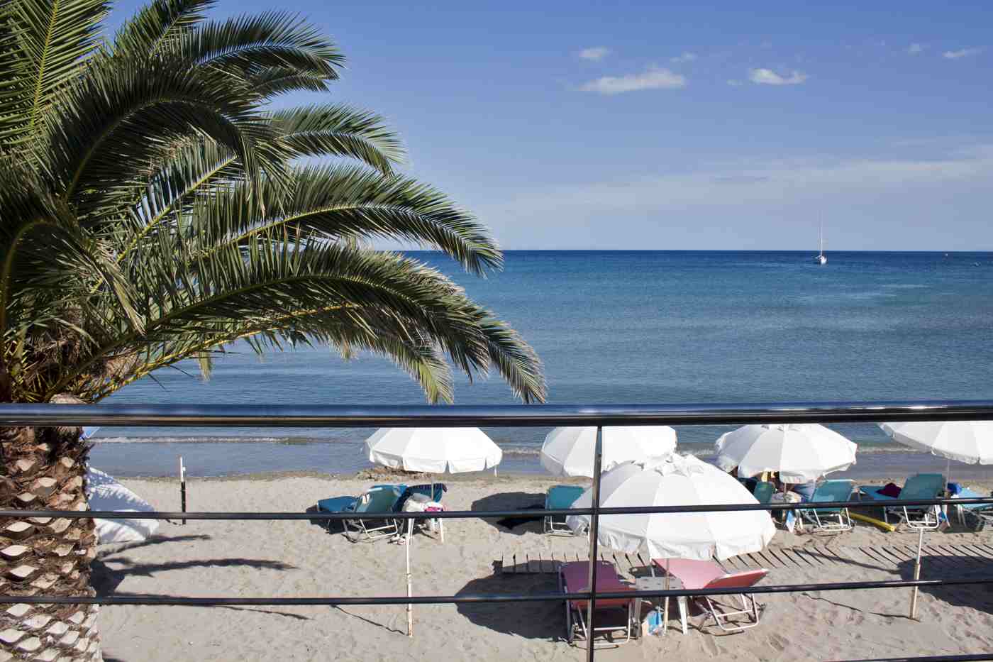 Aegina beaches: the sandy resort beach of Agia Marina with its umbrellas and clear blue sea