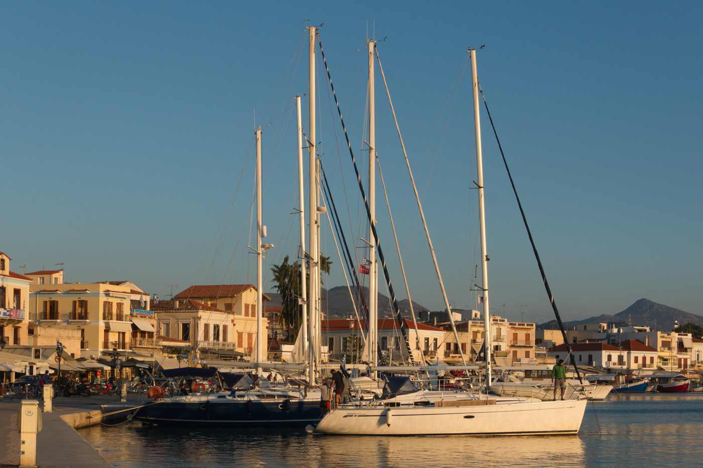 Sailing yachts moored in the harbour of Aegina Town at golden hour