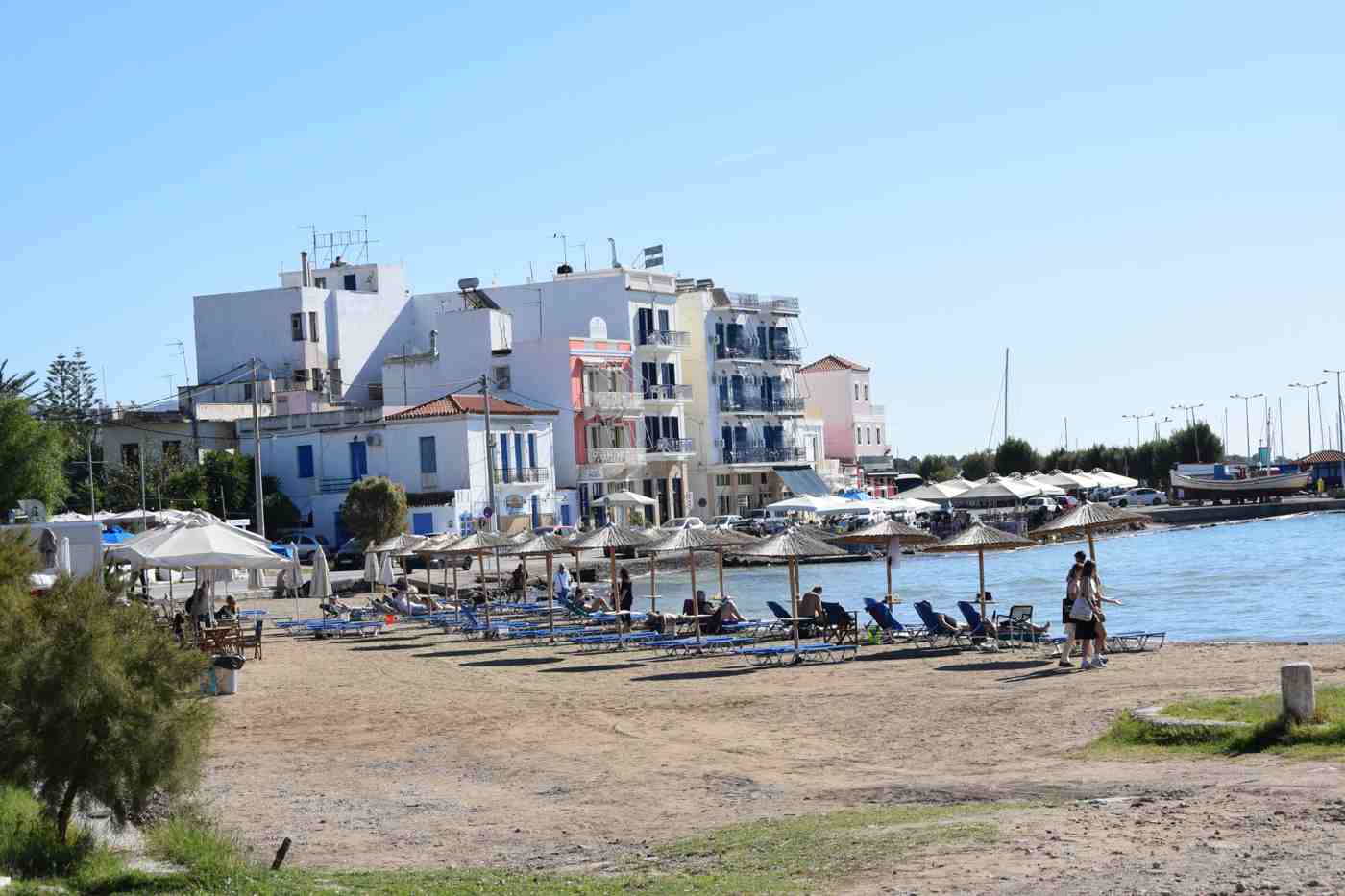 A sandy, shallow family beach with sun umbrellas on Aegina