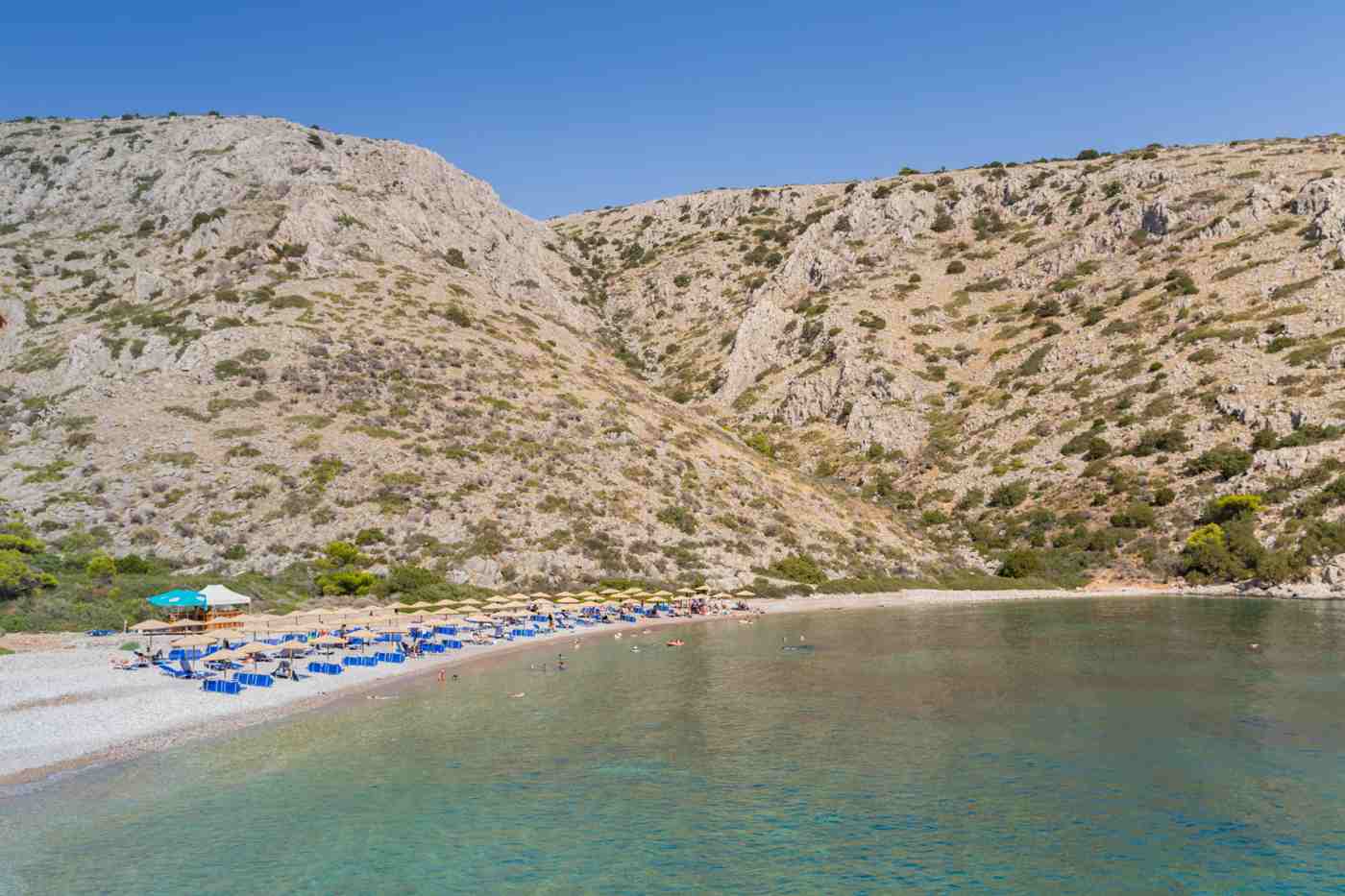Agios Nikolaos beach on Hydra, a large organised Blue Flag cove with sunbeds and clear water