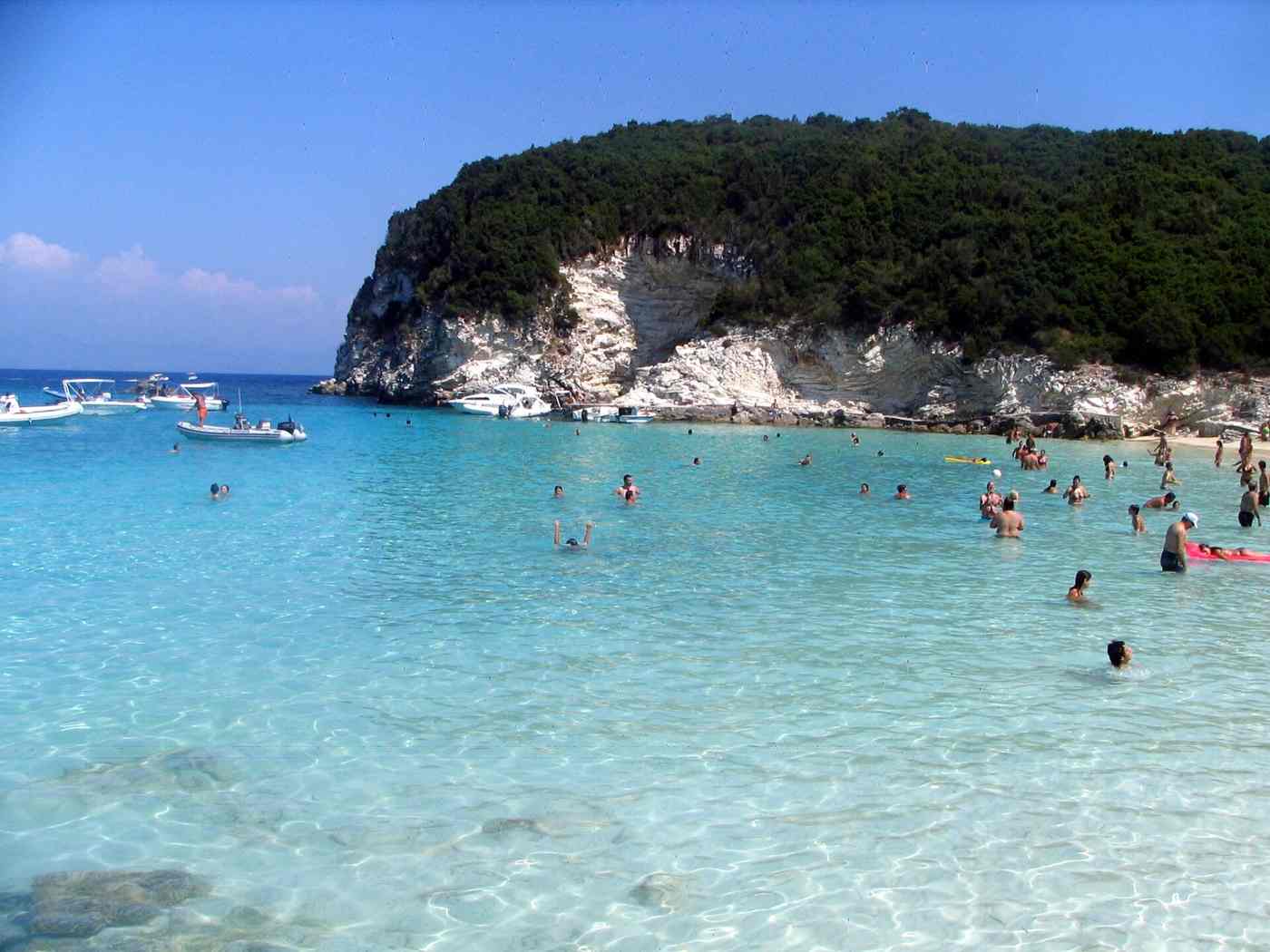 Swimmers and boats in the turquoise bay of Antipaxos