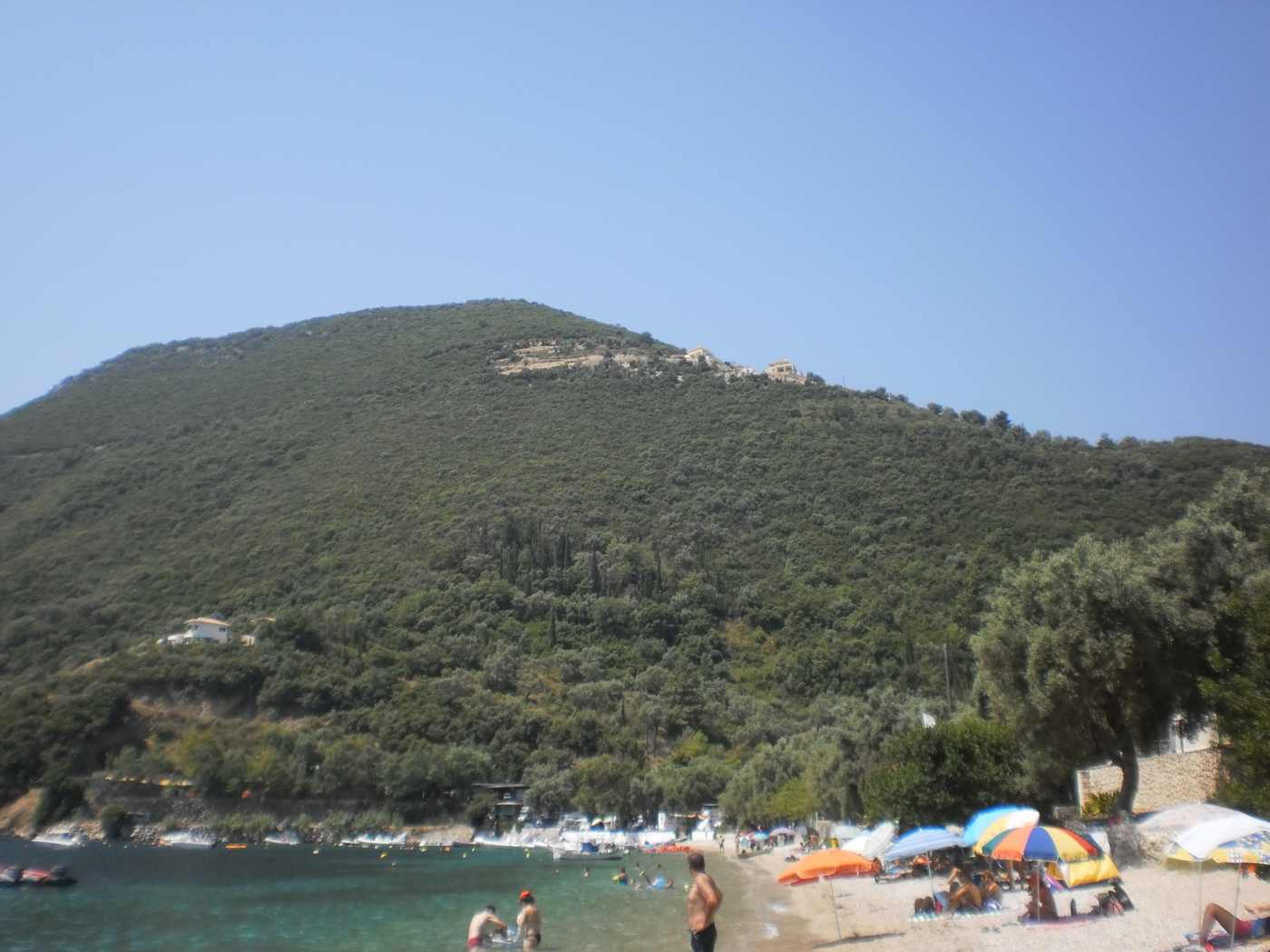 Desimi beach with pebbles, sunbeds and calm water near Nydri, Lefkada