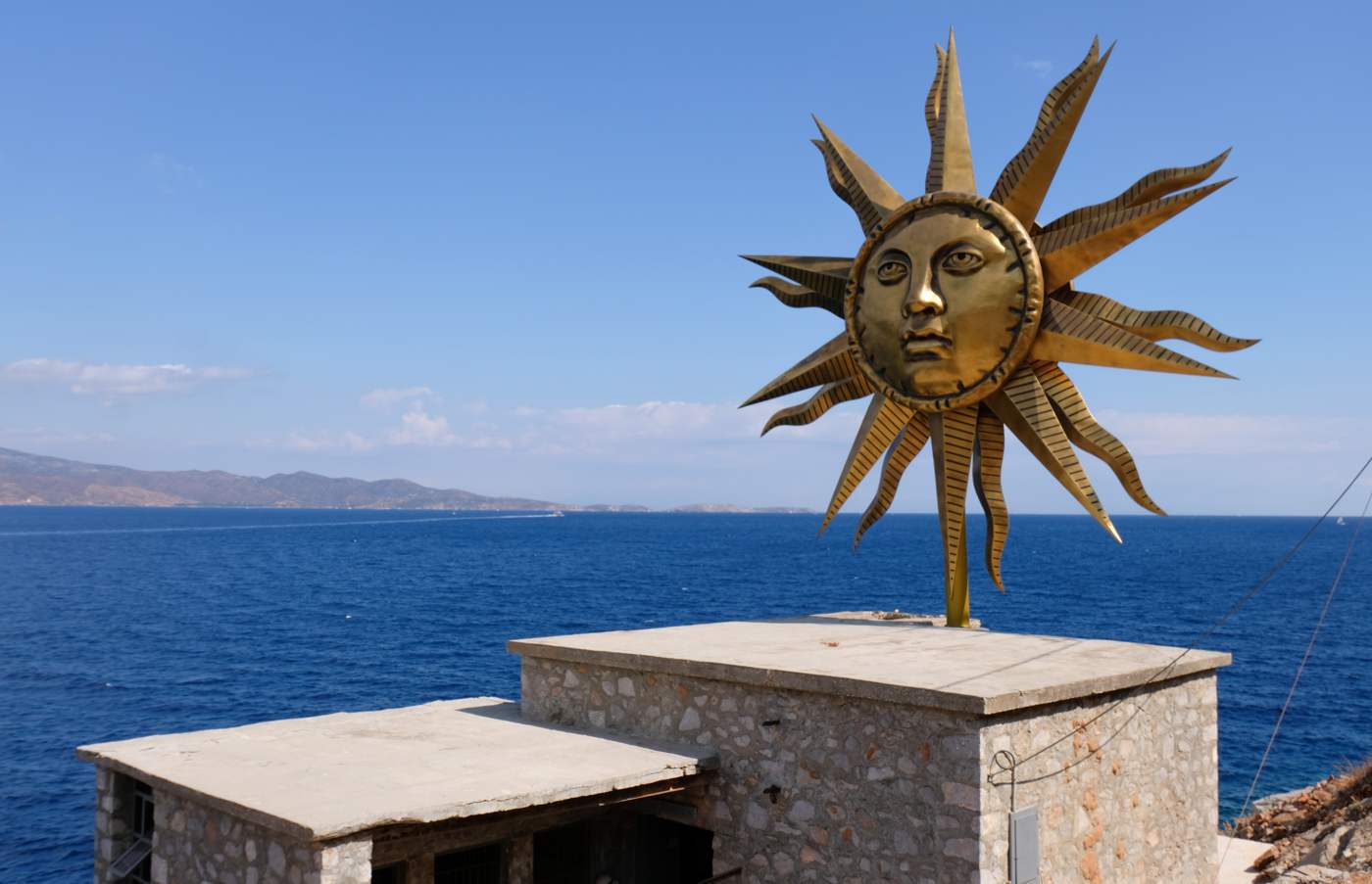Contemporary art on Hydra: Jeff Koons' golden Apollo sun sculpture above the sea, part of the island's summer art project