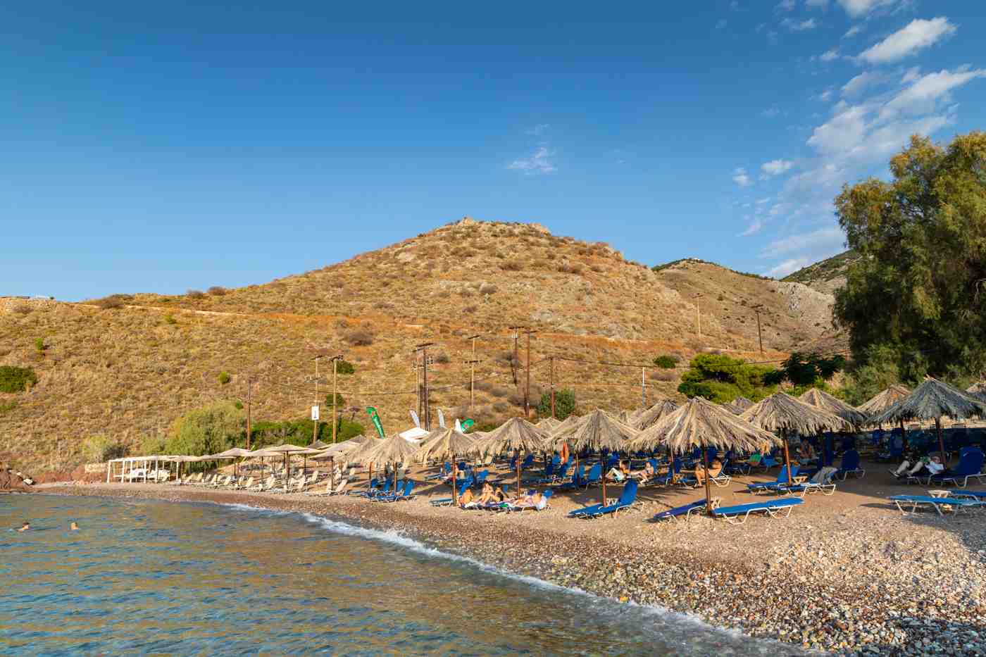Vlychos, a pebble beach with umbrellas among the Hydra beaches