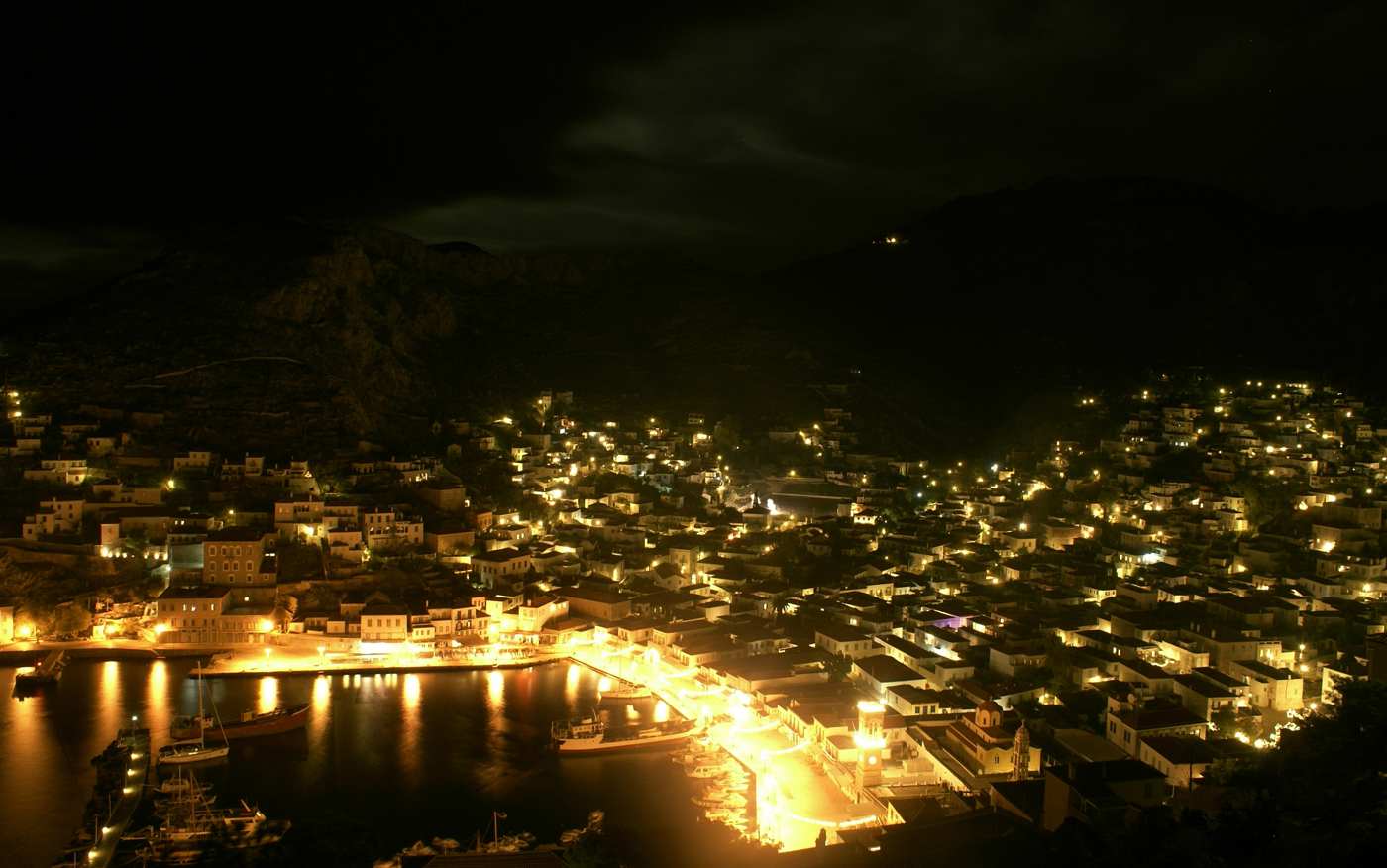 Hydra nightlife: the harbour and stone town glowing with lights at night