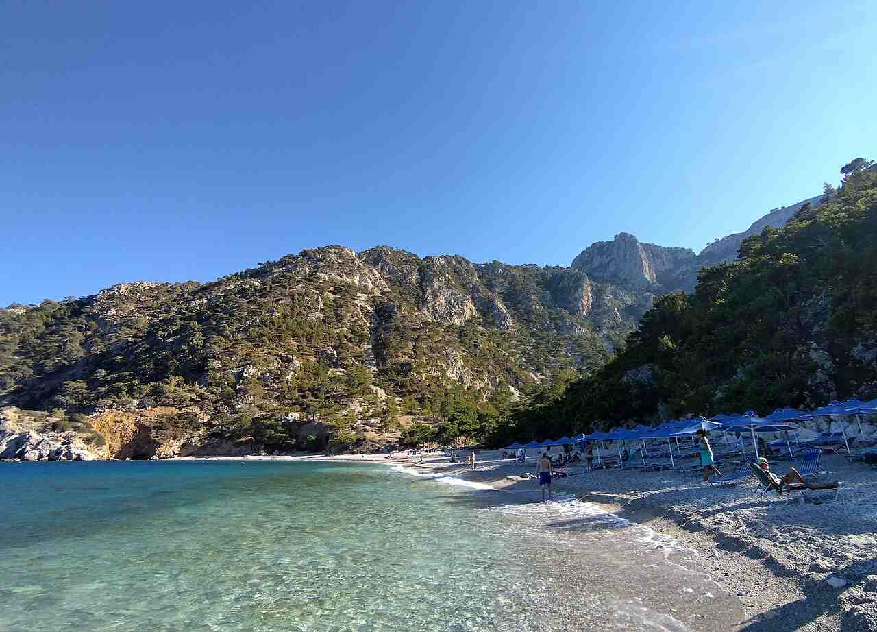 Apella beach on Karpathos with turquoise water below a pine-clad slope
