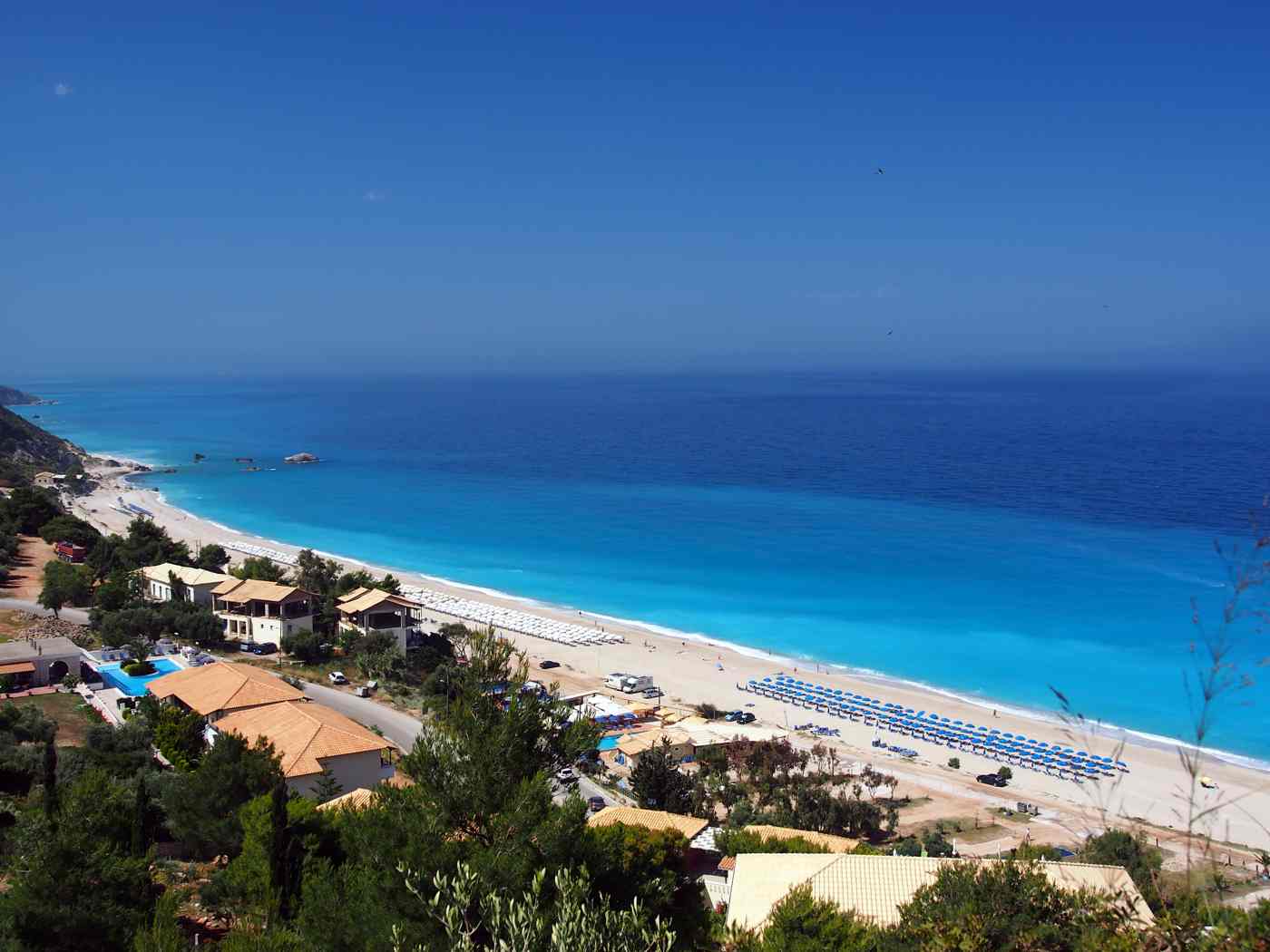 The long sandy sweep of Kathisma beach below green cliffs, Lefkada