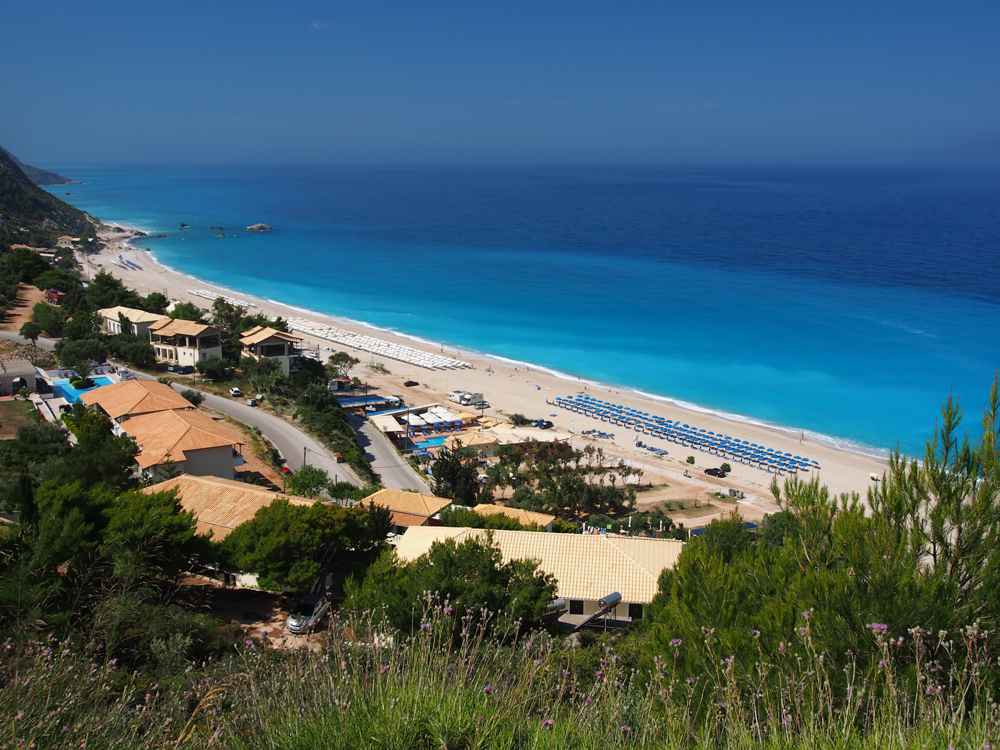 Sunbed rows and turquoise water along Kathisma beach, Lefkada