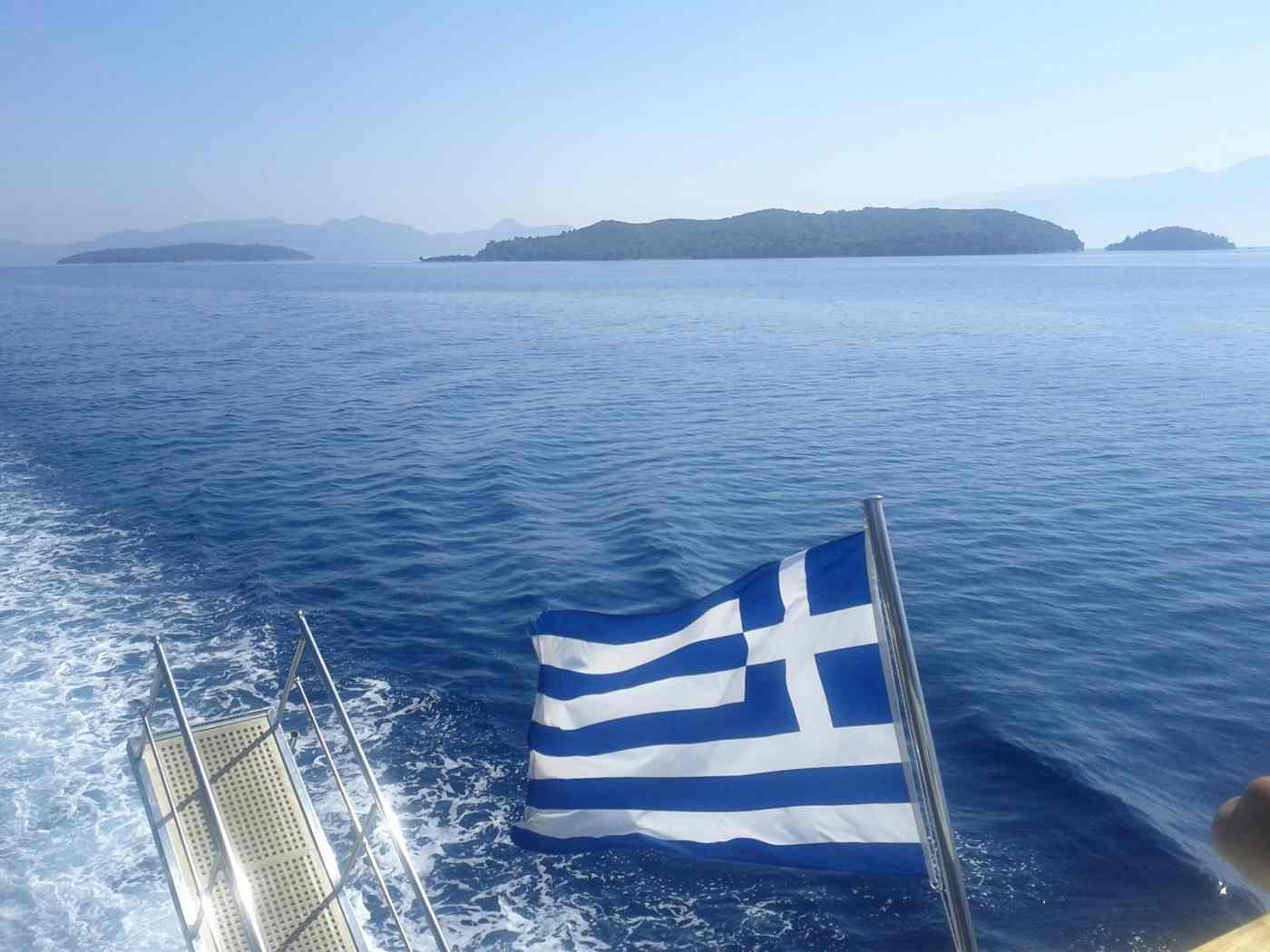 Lefkada sailing in the Ionian, a yacht flying the Greek flag among the islands