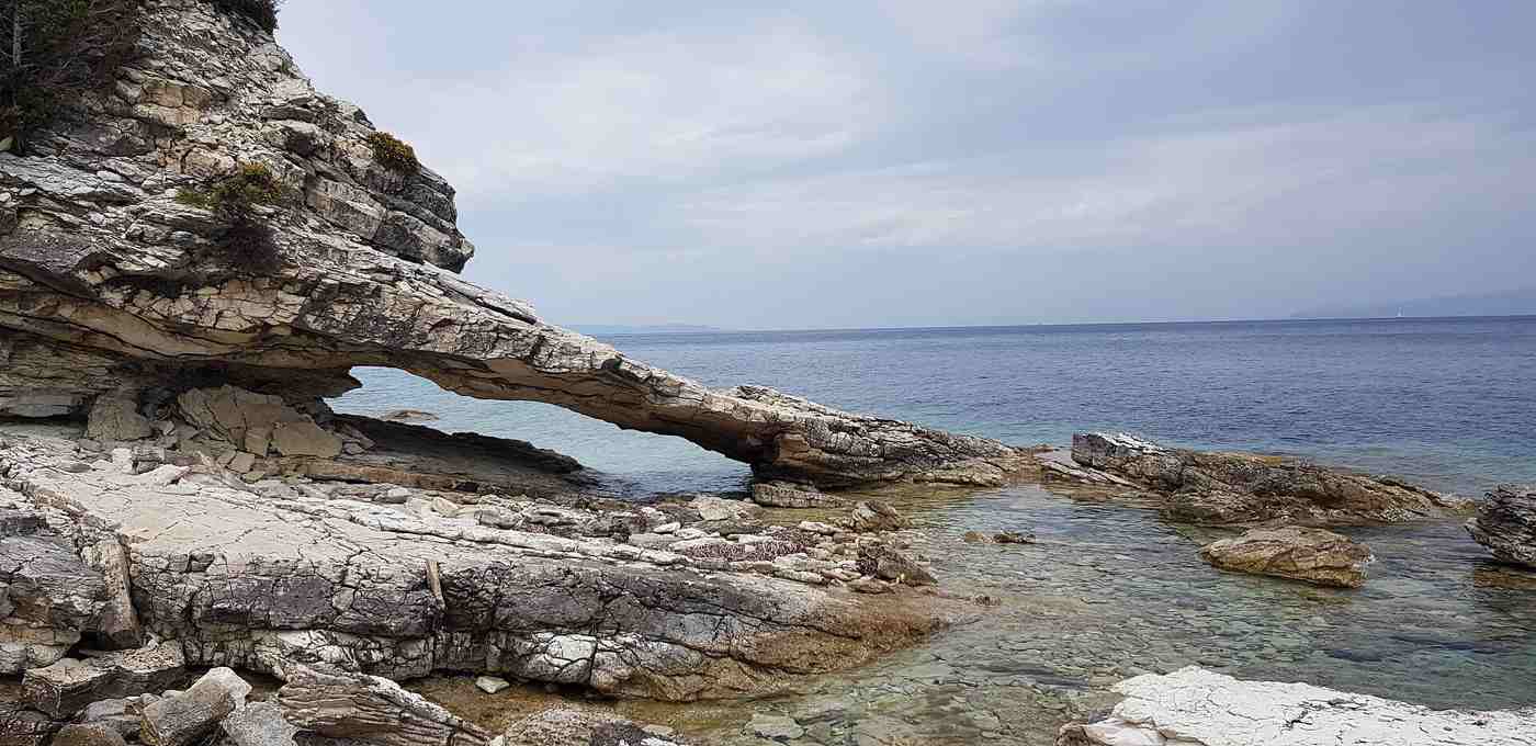 A rocky cove with a natural arch near Marmari beach on Paxos