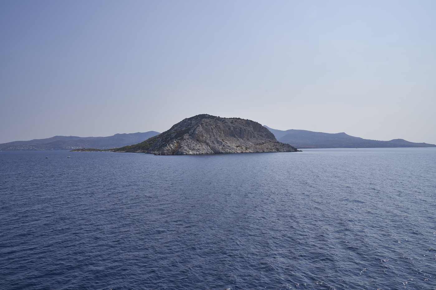The uninhabited pine-topped islet of Moni seen across the sea off Aegina