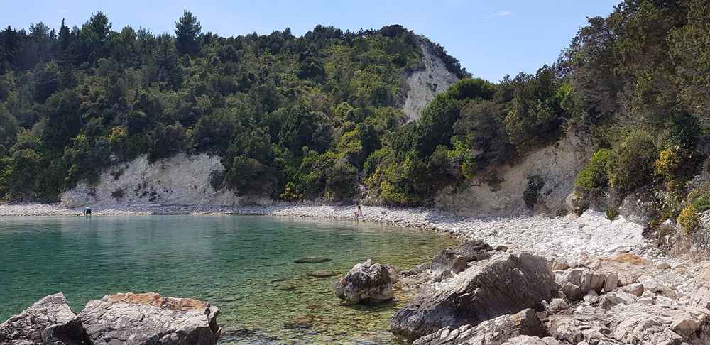 A clear-watered pebbly cove near Lakka on Paxos