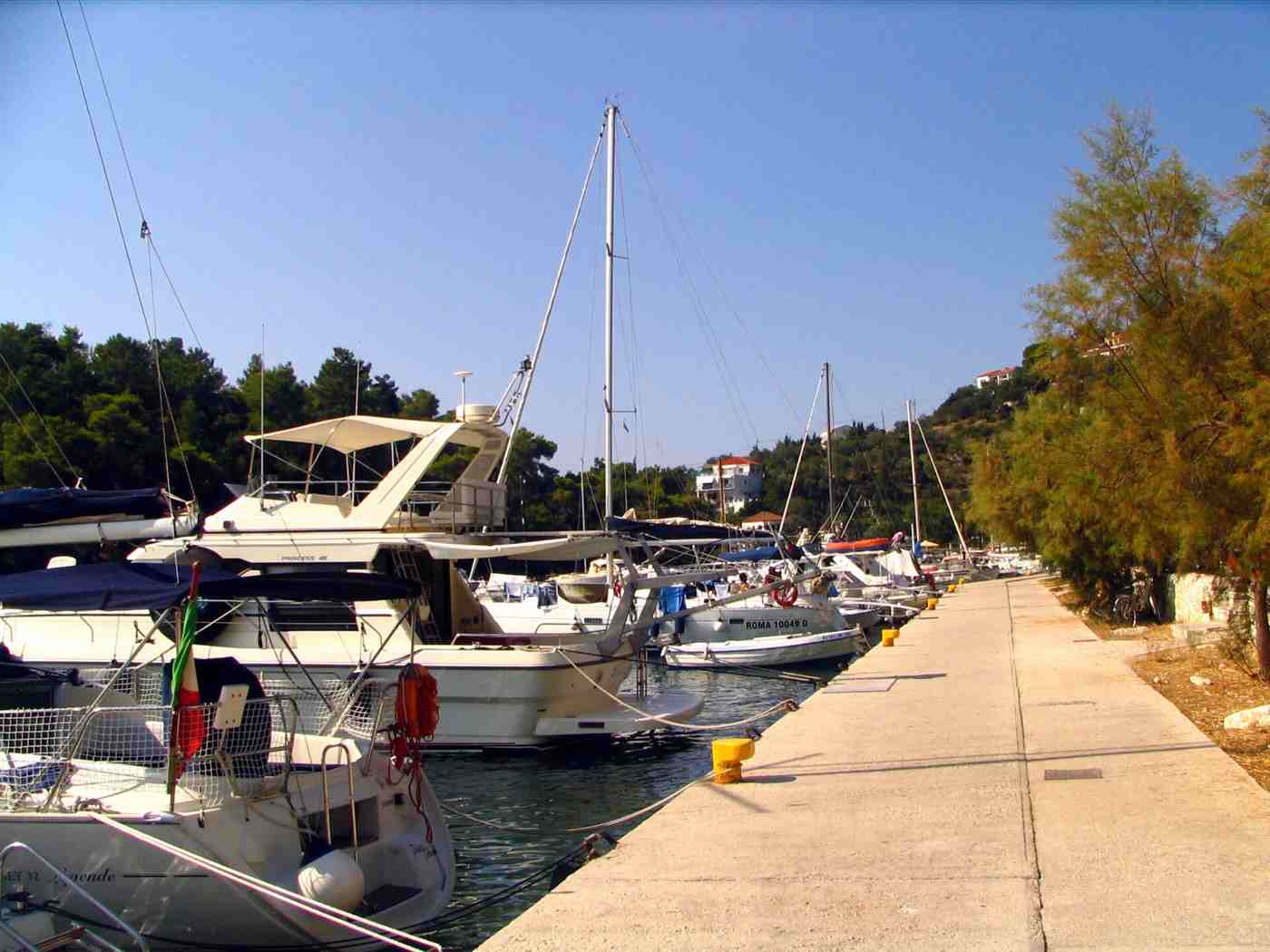 Boats and yachts moored along the harbour quay at Gaios on Paxos