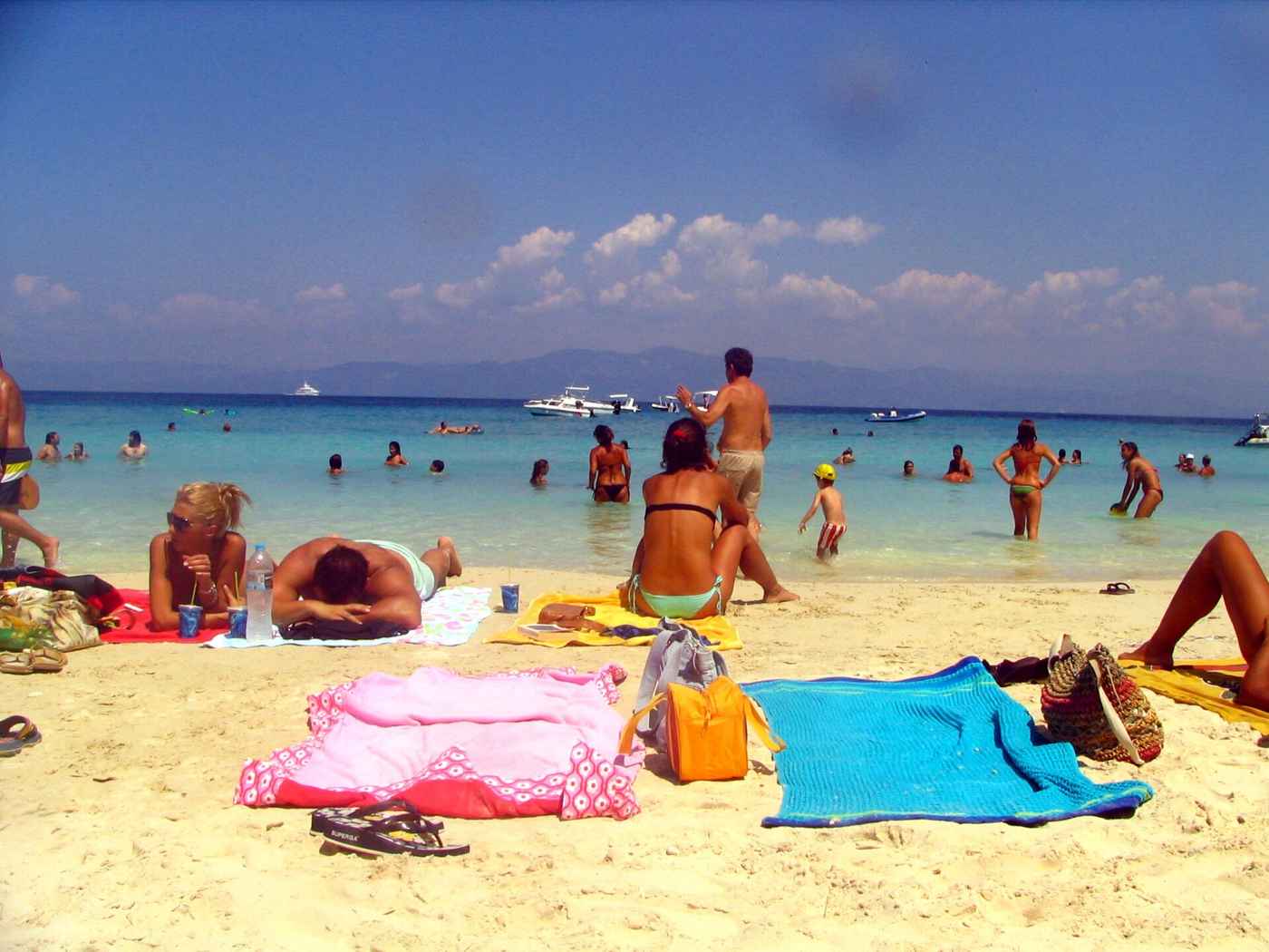 Children and swimmers in the shallow turquoise water at Vrika beach