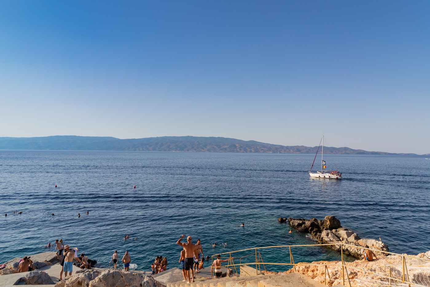 Spilia on Hydra, the rock swimming platforms beside the harbour where swimmers dive into the deep clear sea