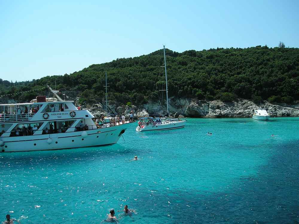 Boats anchored in the clear turquoise water off Antipaxos