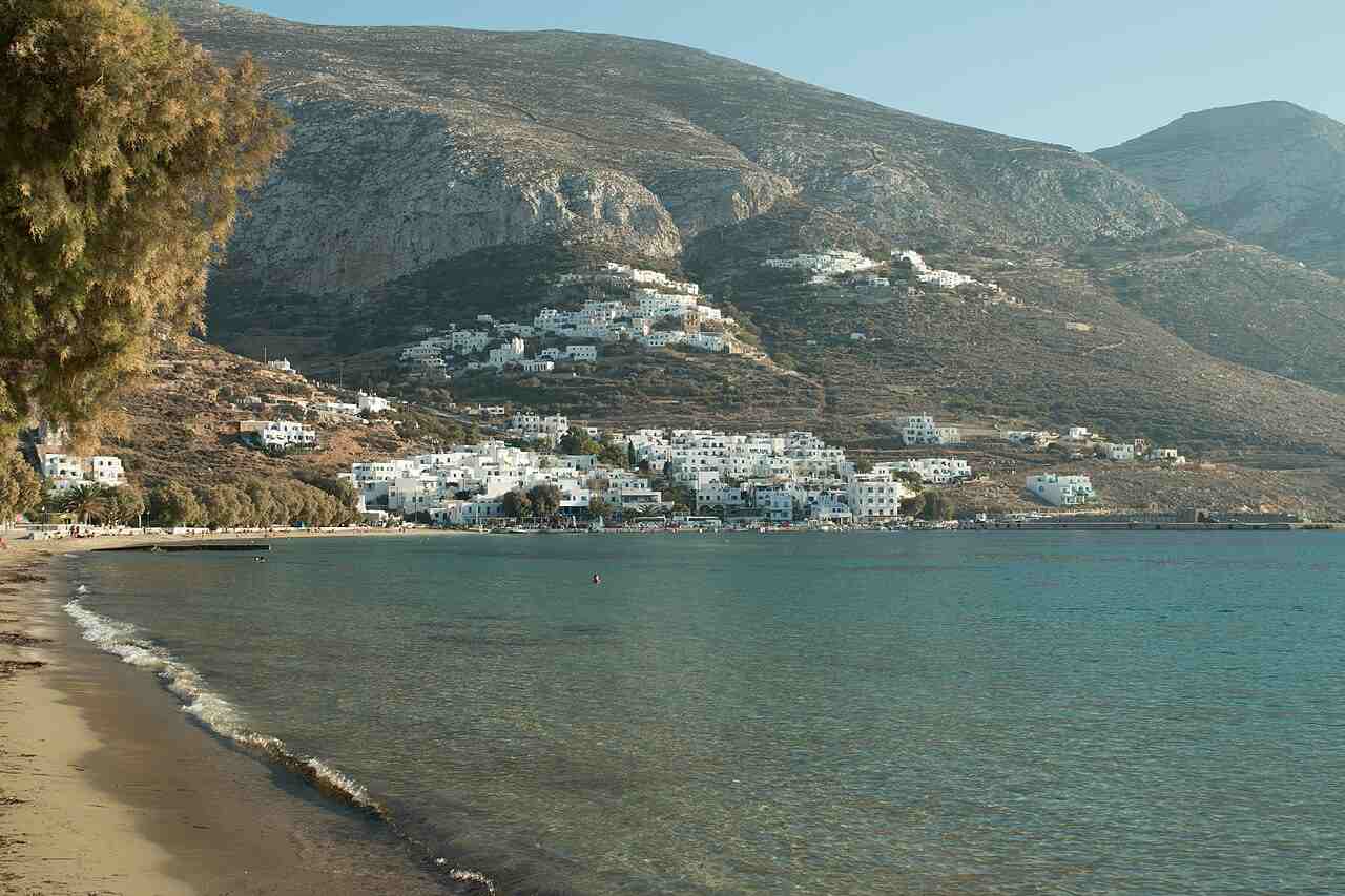 The long sandy beach and turquoise bay of Aegiali with its village on the slope, northern Amorgos