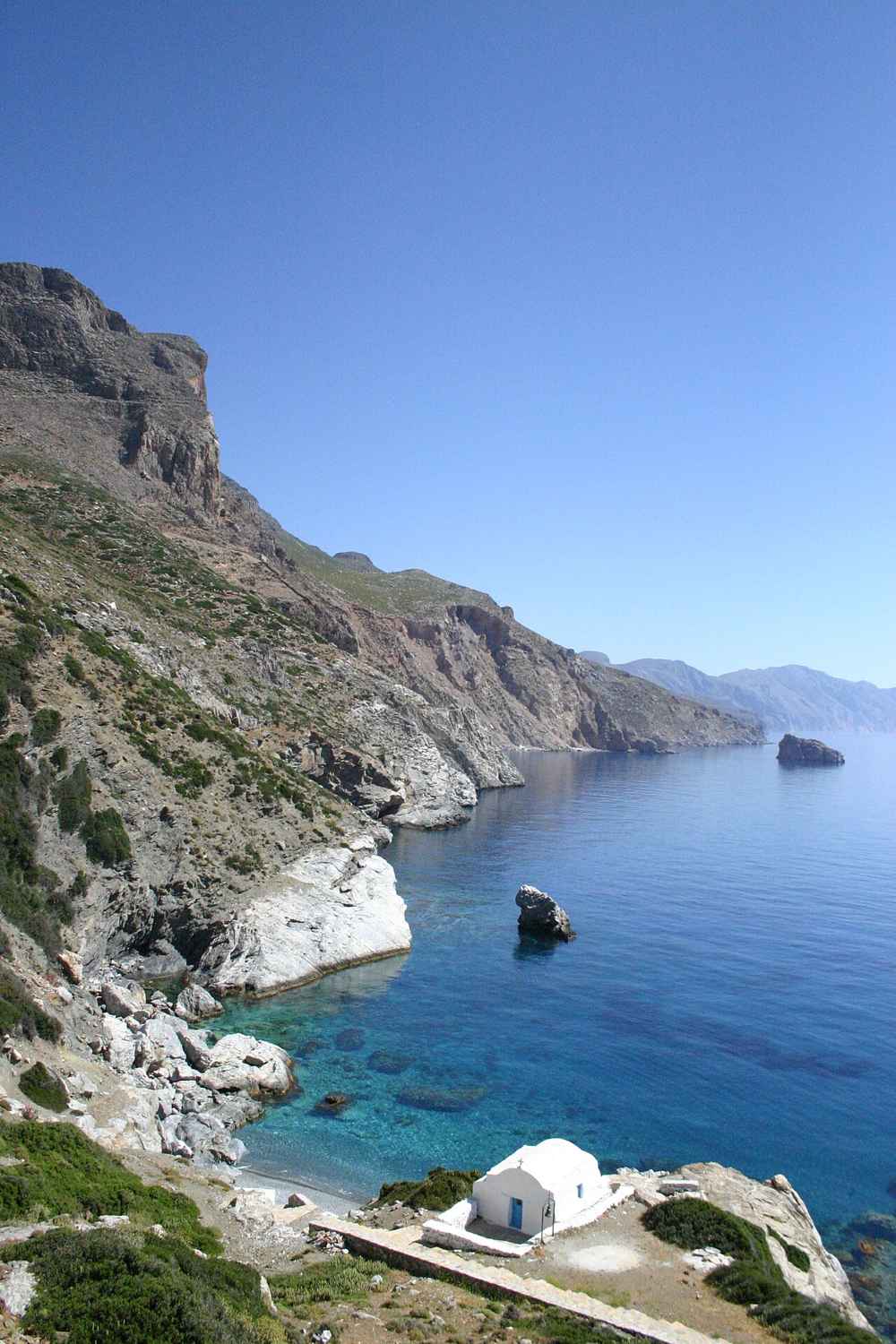 The turquoise cove and white chapel of Agia Anna beneath the cliffs of Amorgos, of Big Blue fame