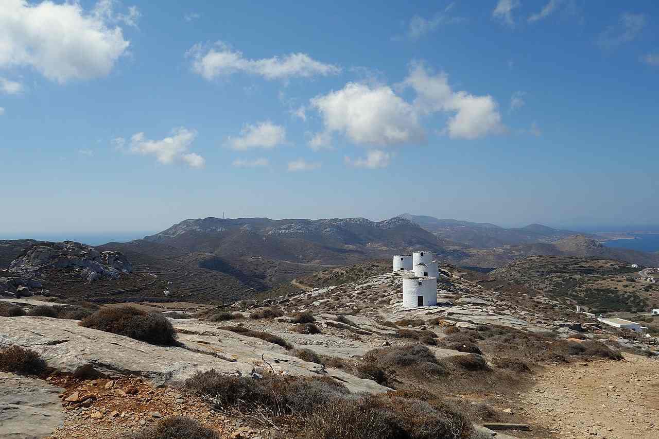 An old stone windmill on the ridge above Chora, with the sea and mountains of Amorgos beyond