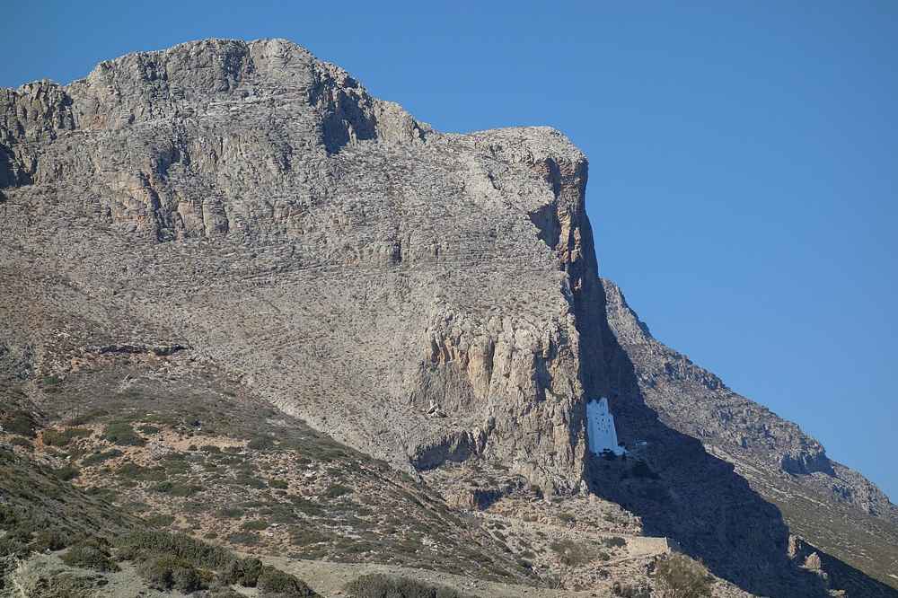 The Hozoviotissa Monastery, a tiny white speck tucked into the vast grey cliff of Amorgos above the sea