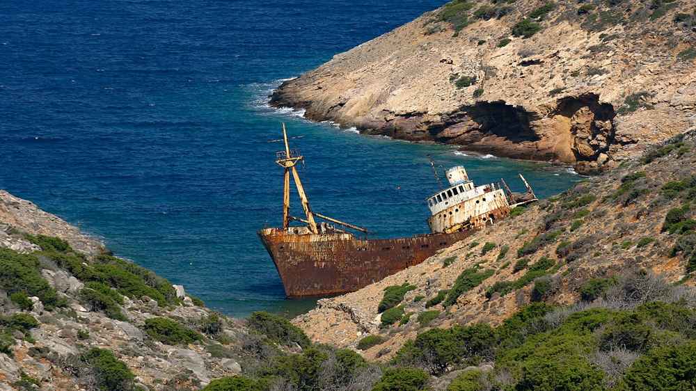 The wreck of the cargo ship Olympia against the cliffs and clear water of southern Amorgos, a Big Blue landmark