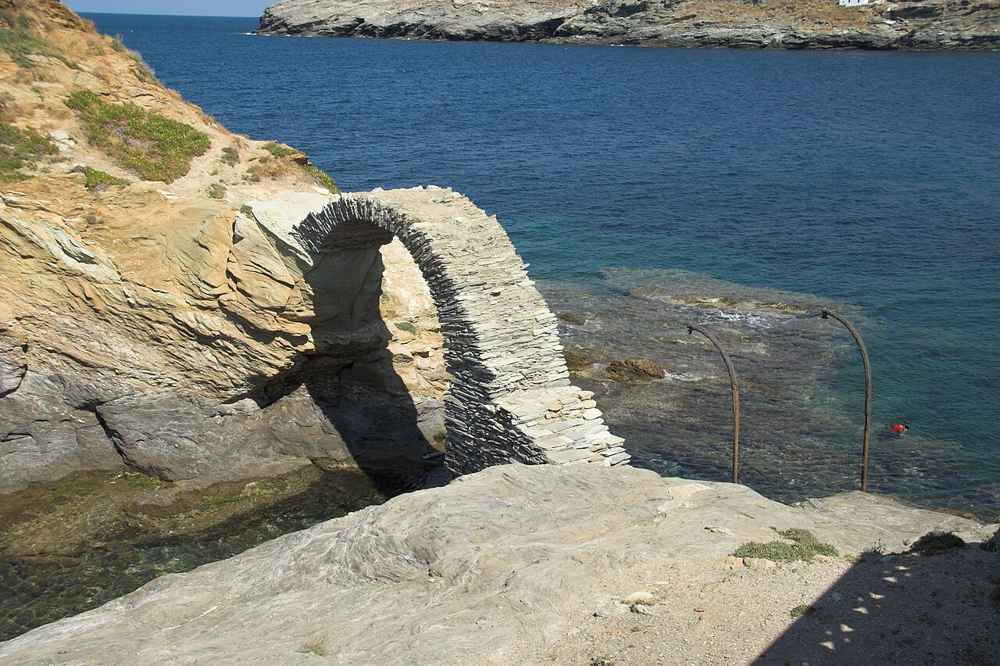 The old arched stone bridge to the Venetian castle islet at Chora, Andros