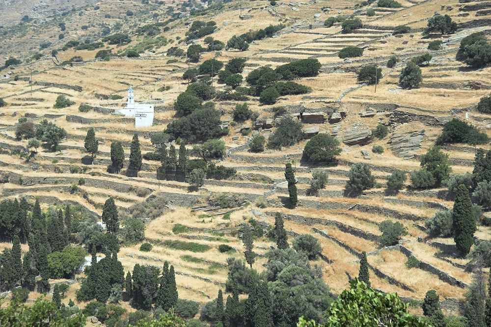 Terraced fields, a white chapel and cypresses on the site of the ancient capital of Palaiopolis, Andros
