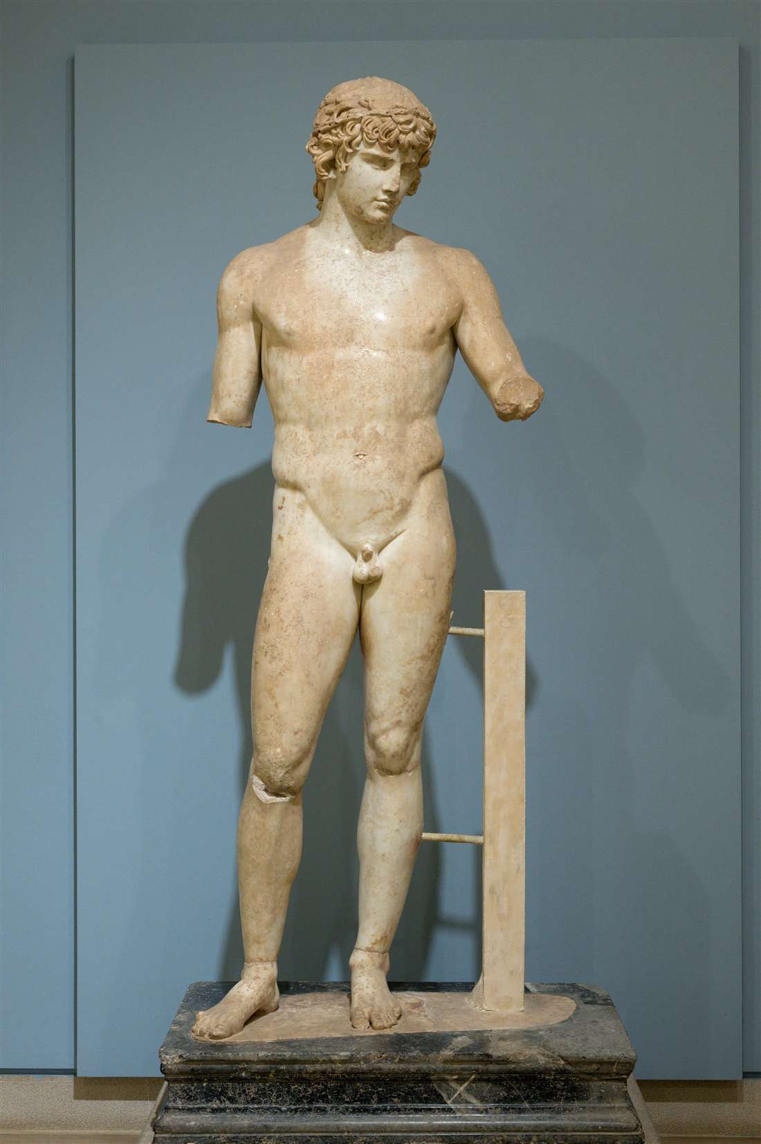 The full standing marble statue of Antinous on its pedestal in the Delphi museum