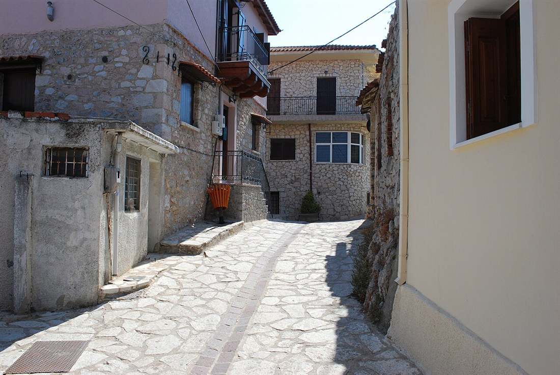A stone-paved lane between the grey stone houses of Arachova on Mount Parnassus