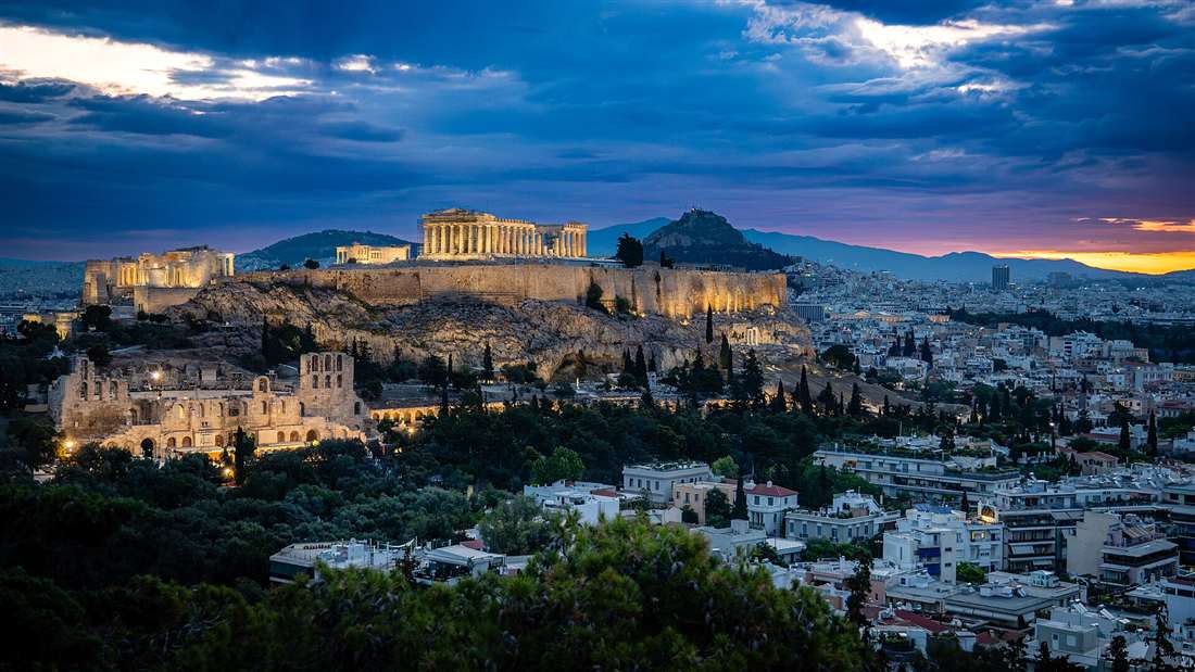 The Acropolis and Parthenon lit at twilight over the city of Athens, the destination for airport transfers from Athens International Airport