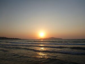 A calm sandy Chania beach at golden hour, a family swimming spot