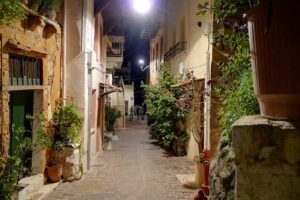 A lamplit old-town alley in Chania in the evening
