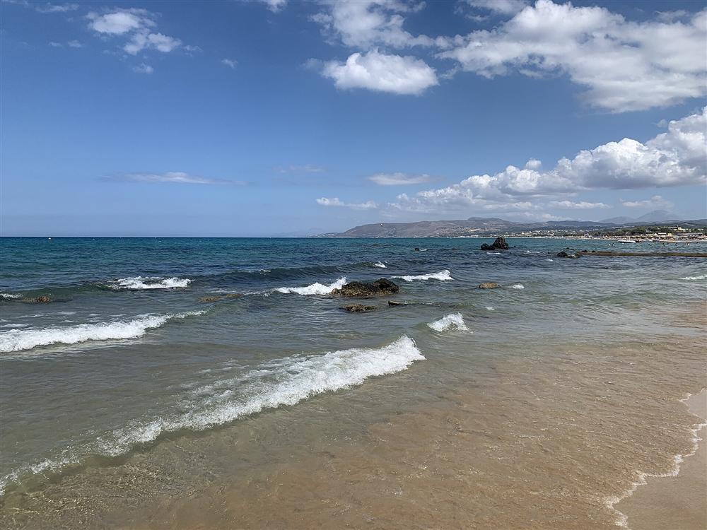 The long sandy beach at Georgioupoli, Crete, with the White Mountains behind