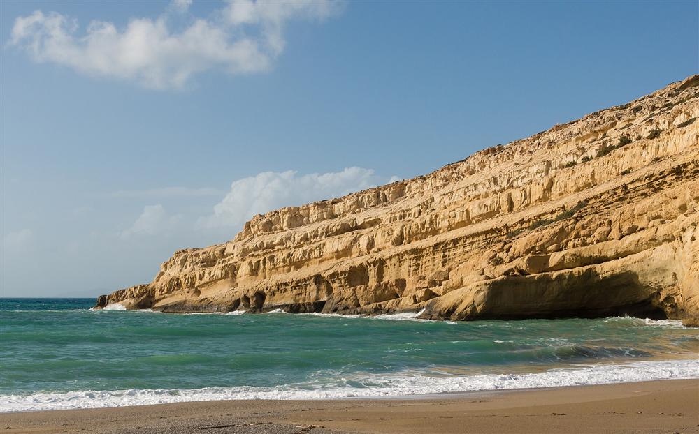 The golden sandstone headland and turquoise sea at Matala beach, Crete