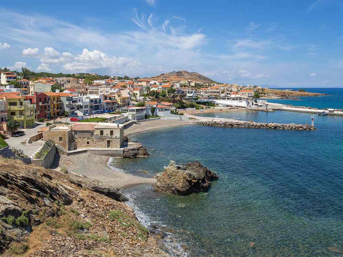 The stone village and small Venetian harbour of Panormos on the north coast of Crete, with its sandy cove beach and breakwater