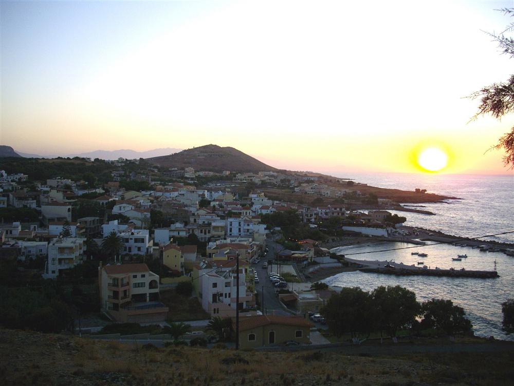 The seaside village of Panormos in the Rethymno region of Crete at sunset, its houses climbing above the harbour