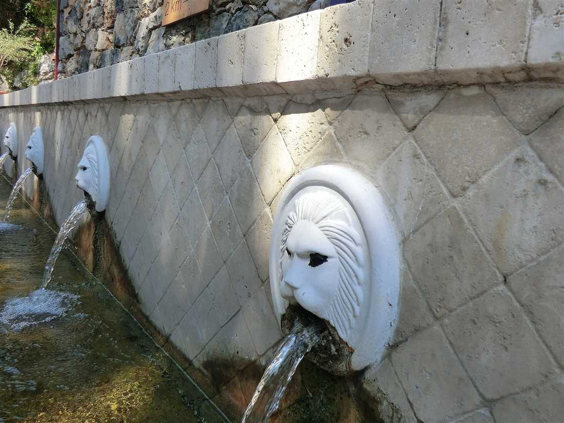 The Venetian lion-head fountain of Spili in the Rethymno mountains of Crete, a row of carved marble spouts pouring spring water