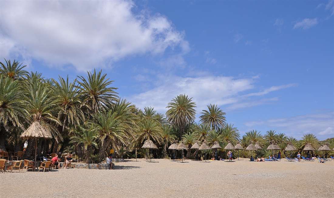 The palm-forest beach at Vai on the far north-east tip of Crete, the largest natural palm grove in Europe, with golden sand and thatched umbrellas