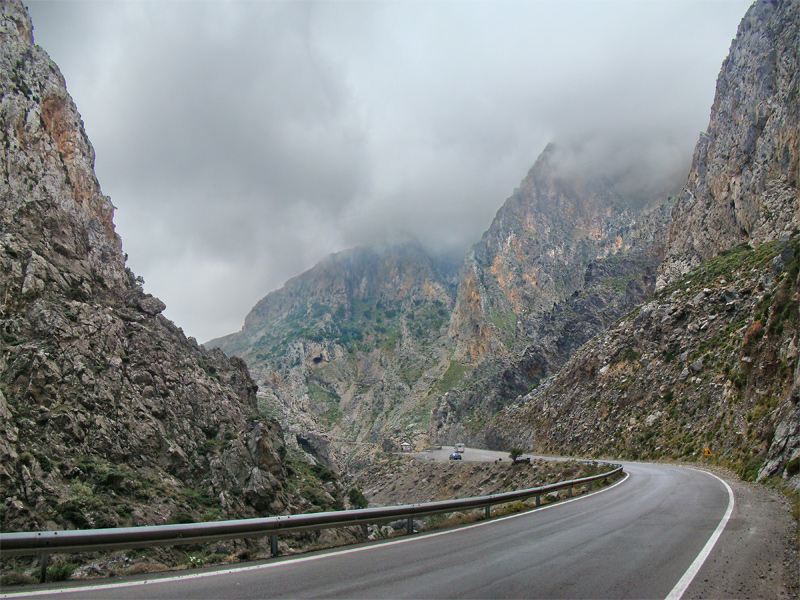 Cars on the road through a dramatic Cretan gorge, driving a hire car in Crete