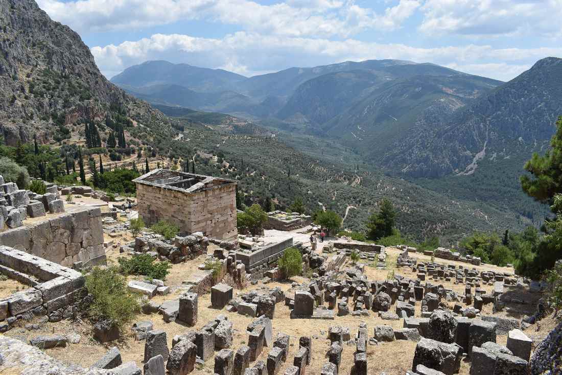 Visitors walking the archaeological site of Ancient Delphi below the Temple of Apollo