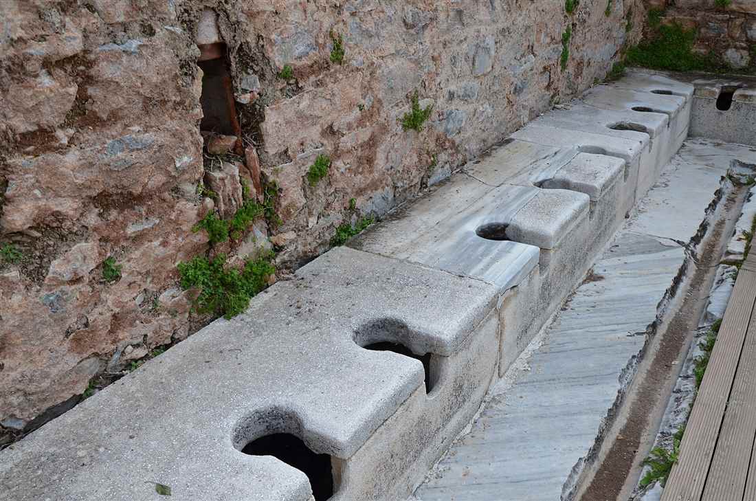 The marble bench seats of the public latrines of Ephesus over the water channel