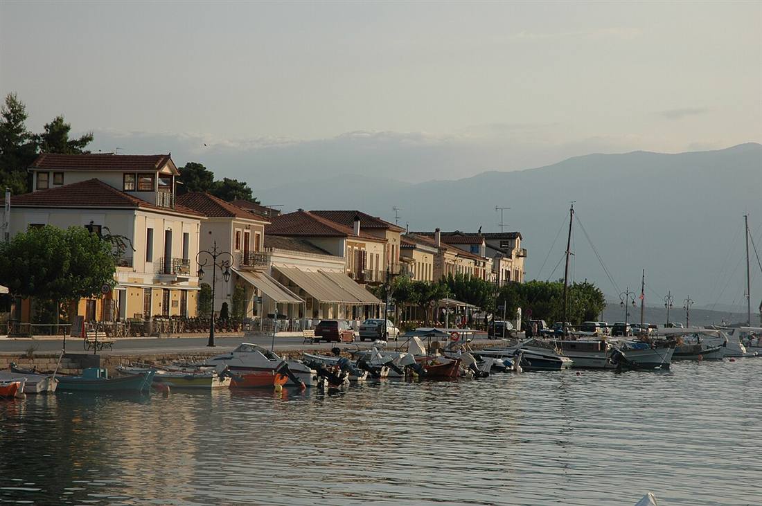 The waterfront of Galaxidi at dusk, its captains mansions and moored boats along the Gulf of Corinth