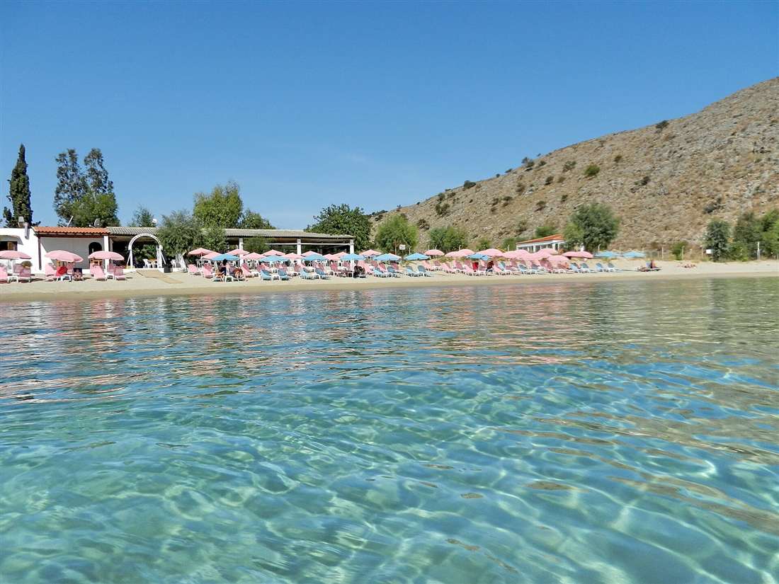 The clear turquoise water and sunbeds of Georgioupolis beach, Crete