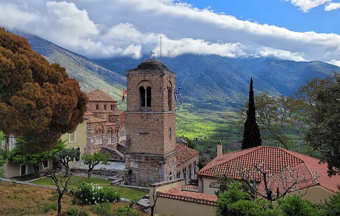 The Byzantine monastery of Hosios Loukas, its stone bell tower and domed churches against the slopes of Mount Helicon