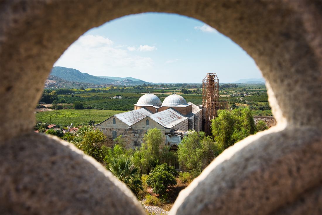 Isa Bey Mosque with its twin domes seen through a stone arch, Selcuk near Ephesus