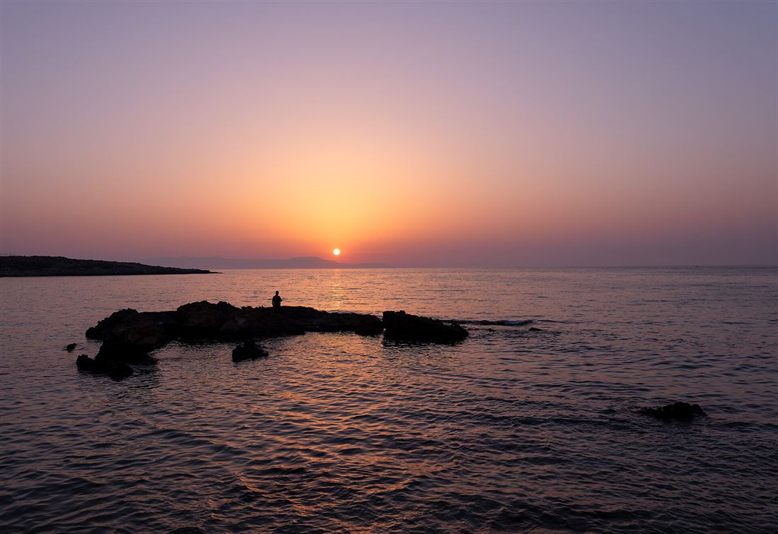 Sunset over the islet at Kalathas beach on the Akrotiri peninsula near Chania