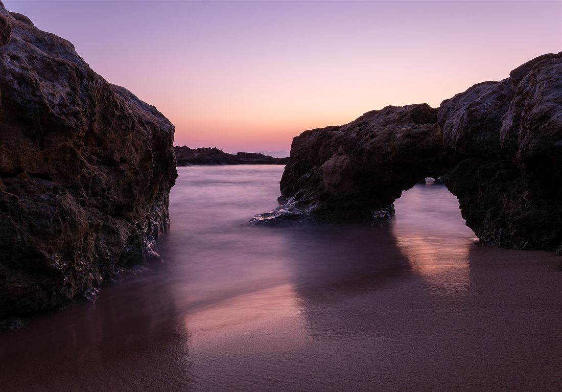A natural rock arch over the sand at Kalathas beach on Akrotiri, Crete