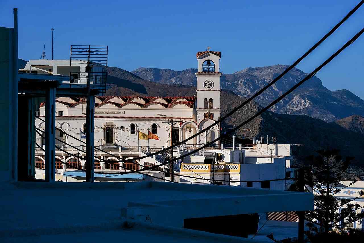 The church and clock tower of Menetes village on Karpathos against the mountains