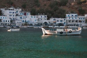 The whitewashed waterfront tavernas and a fishing boat at Loutro, Crete